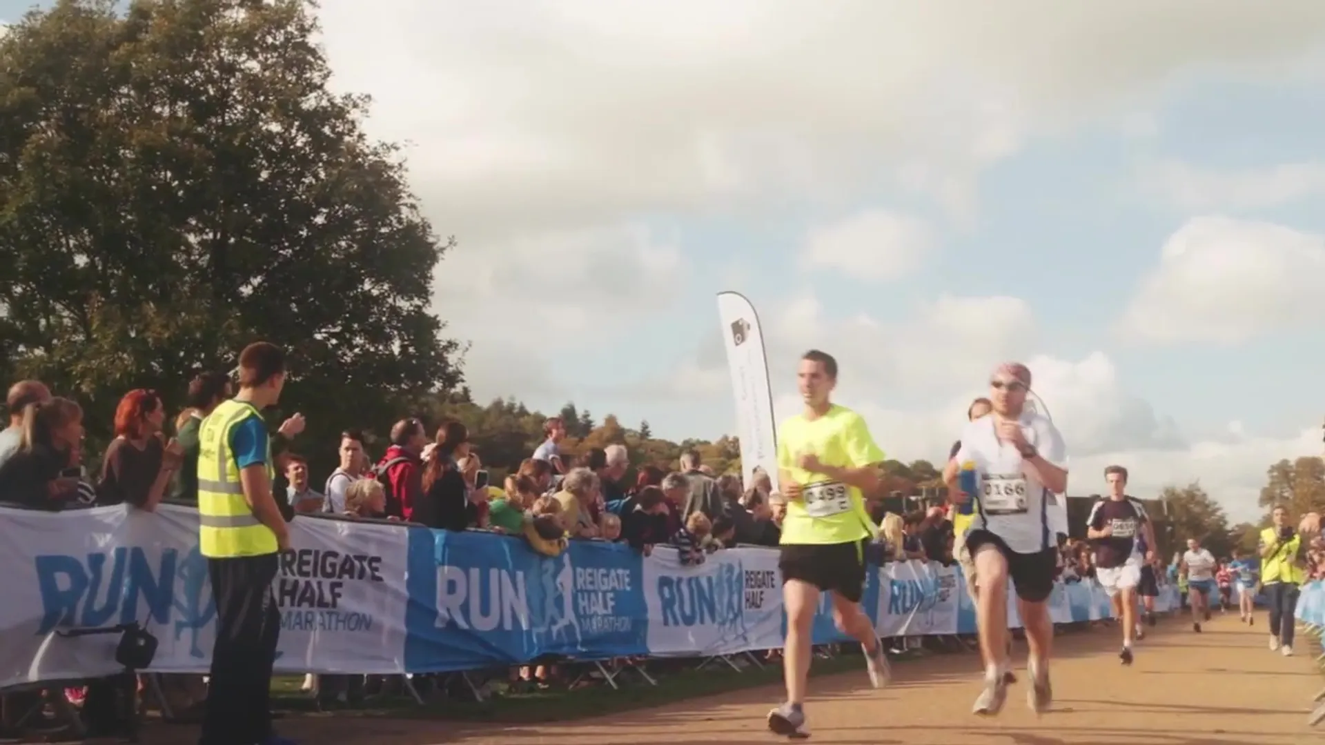 The image shows a scene from a running event, possibly a half marathon, as