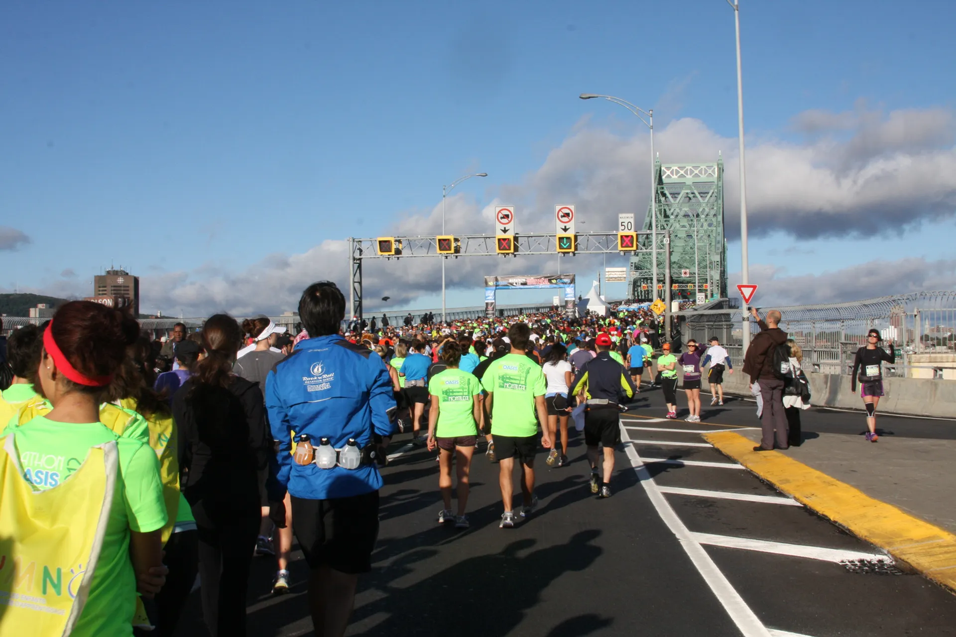 This image shows a group of people participating in a road race. The runners are