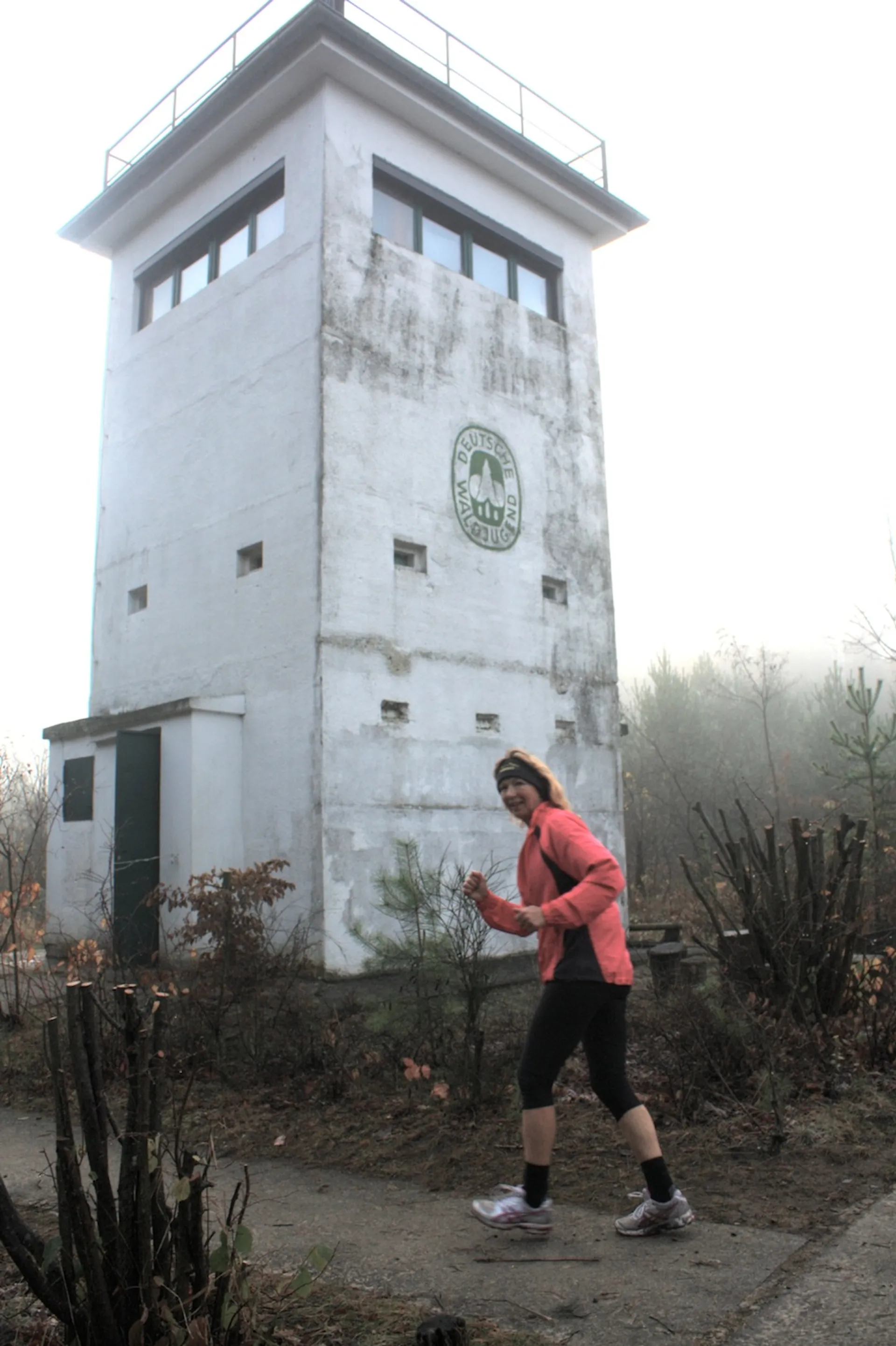 The image shows a person in the foreground who appears to be walking or jogging.