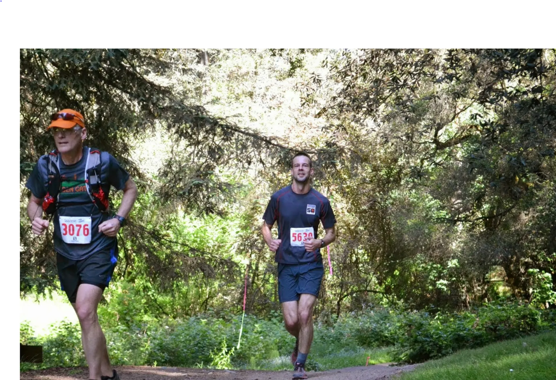 The image shows two individuals participating in a running event, possibly a trail race.