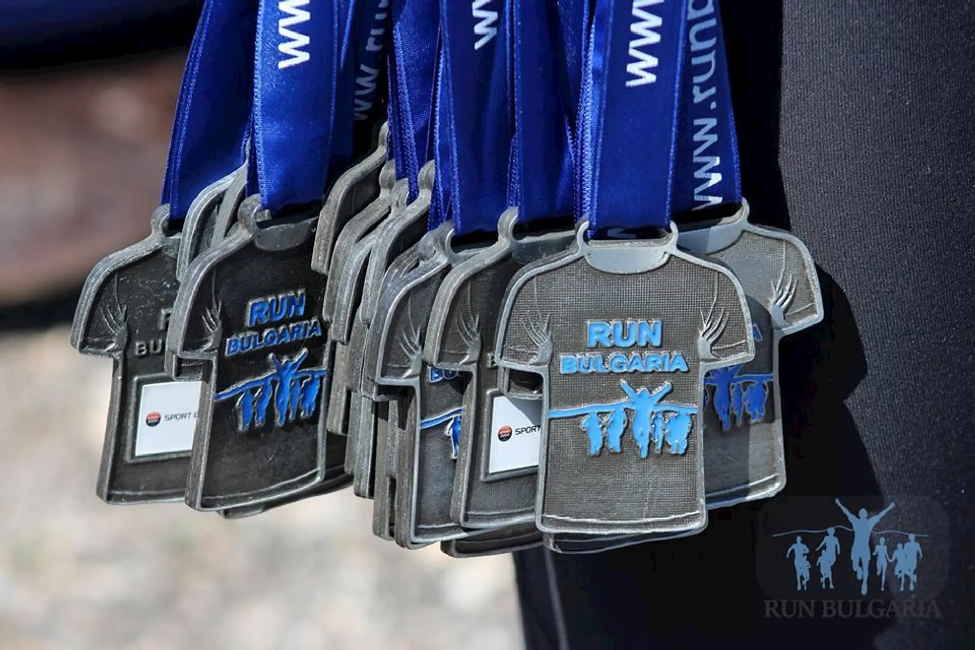The image shows a set of medals hanging from blue ribbons. The medals appear