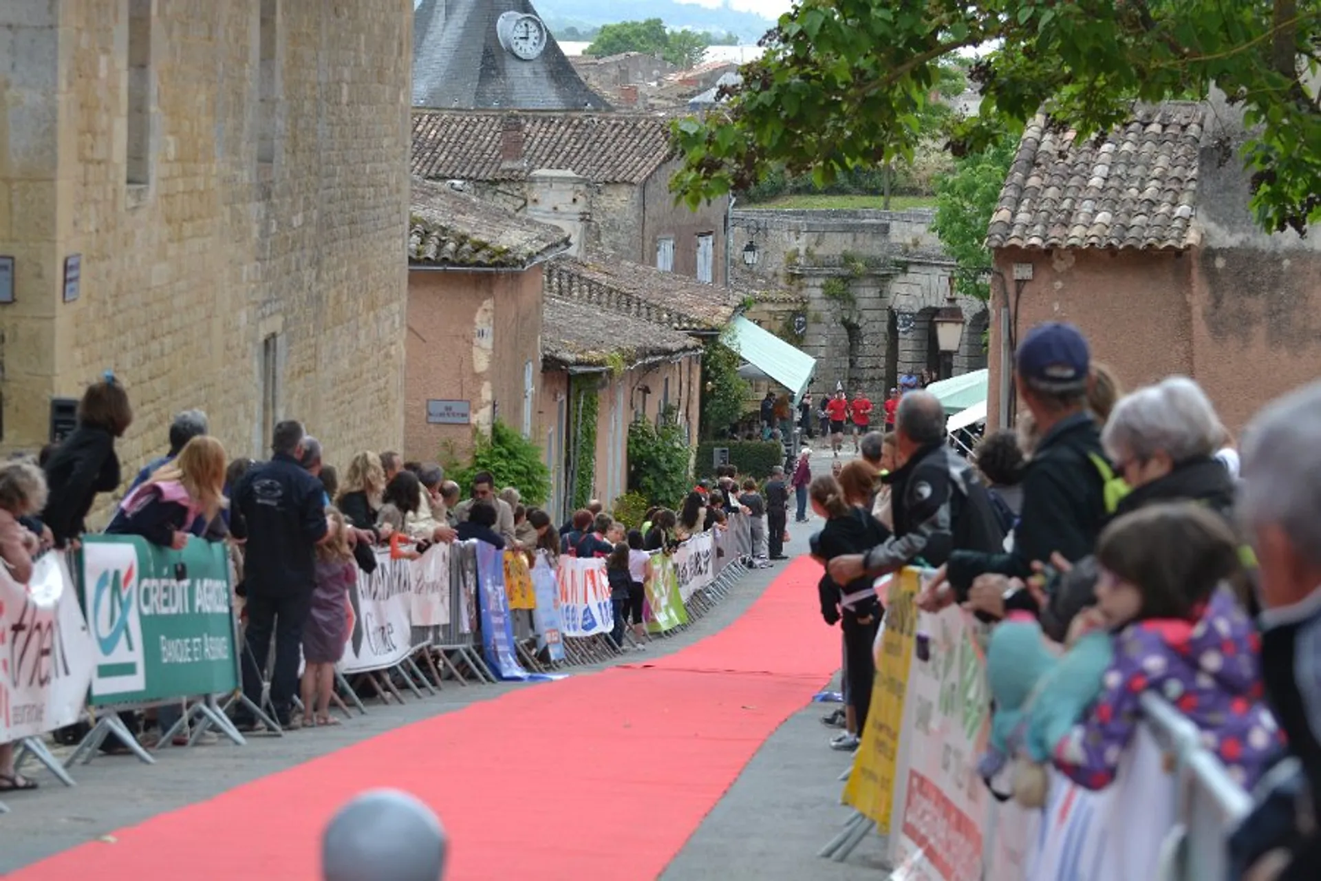 In the image, we see a crowd of people lining a red carpet that runs