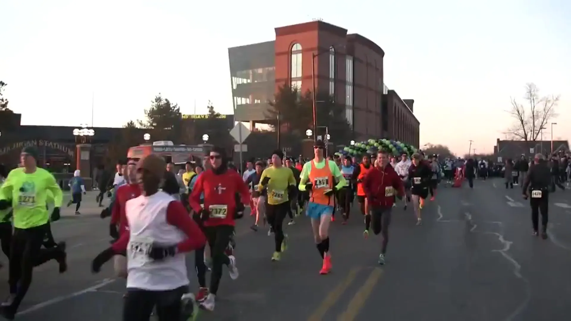 The image shows a group of people participating in a running event. They are dressed