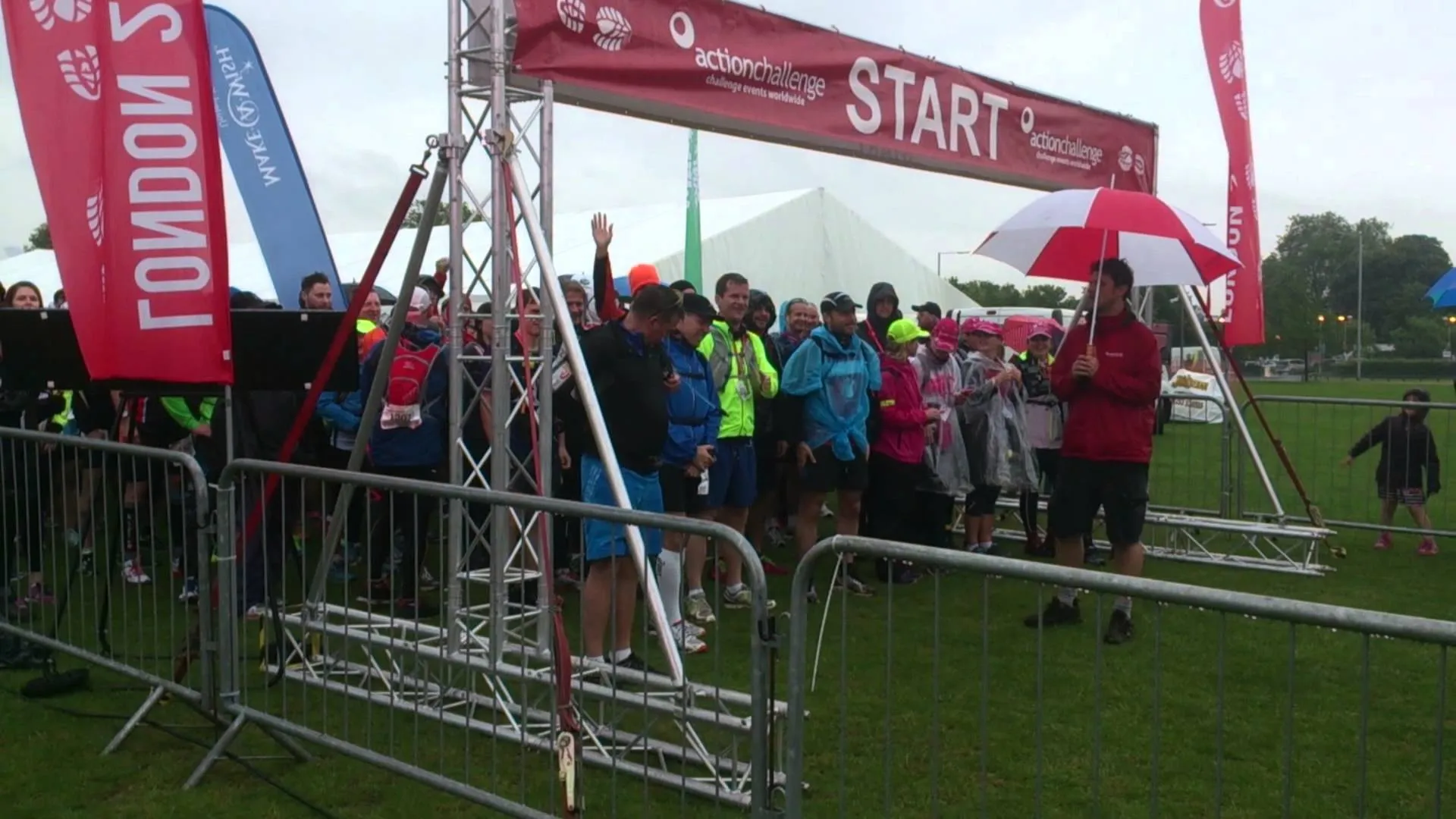 The image depicts a group of people gathered at a start line for a running event