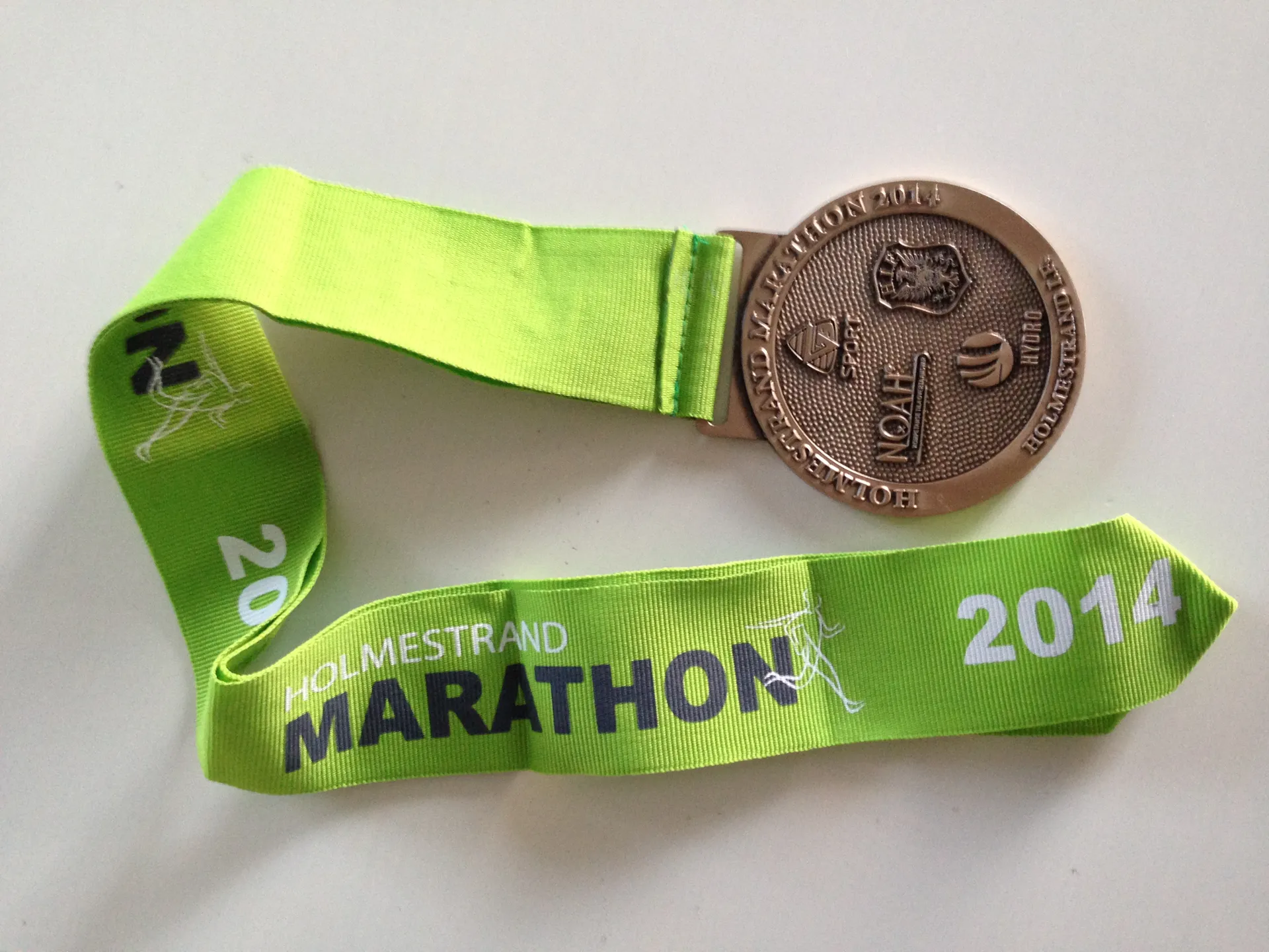 The image shows a finisher's medal from an event called "Holmest