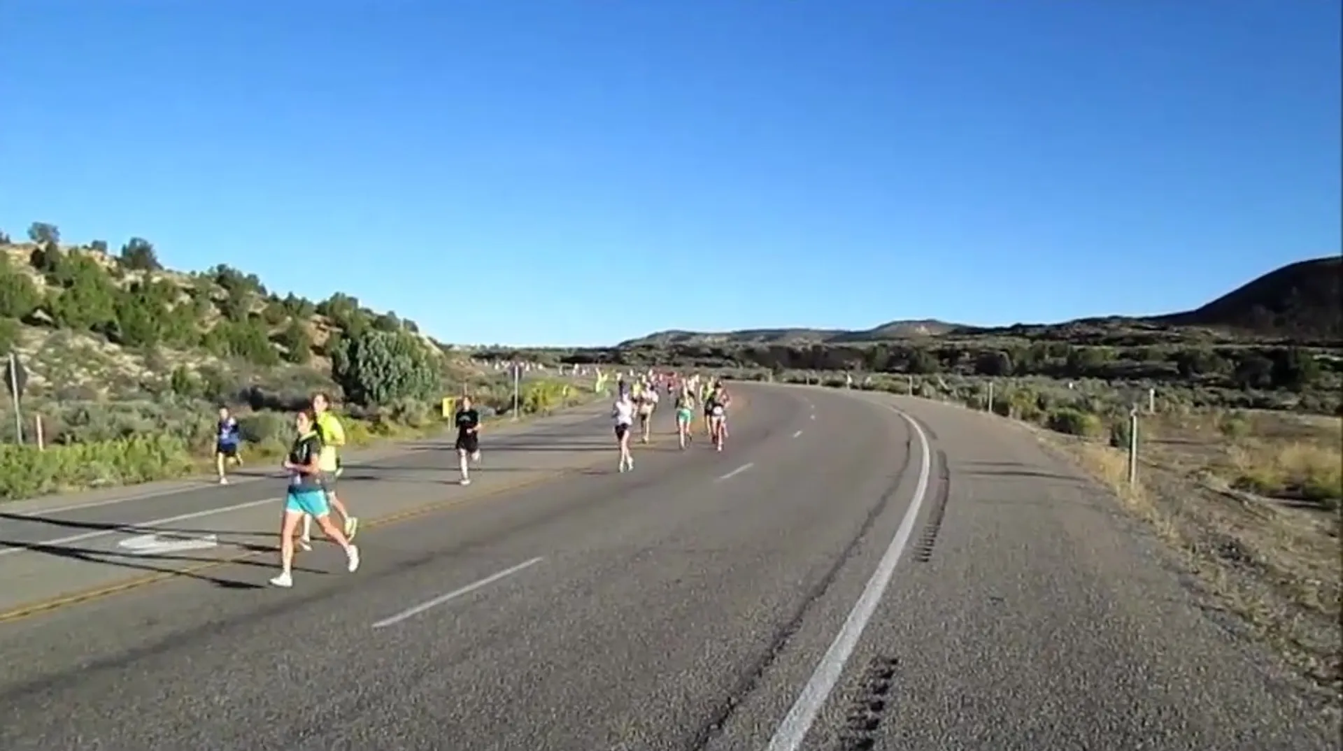 The image shows a group of people running on a road, likely participating in a