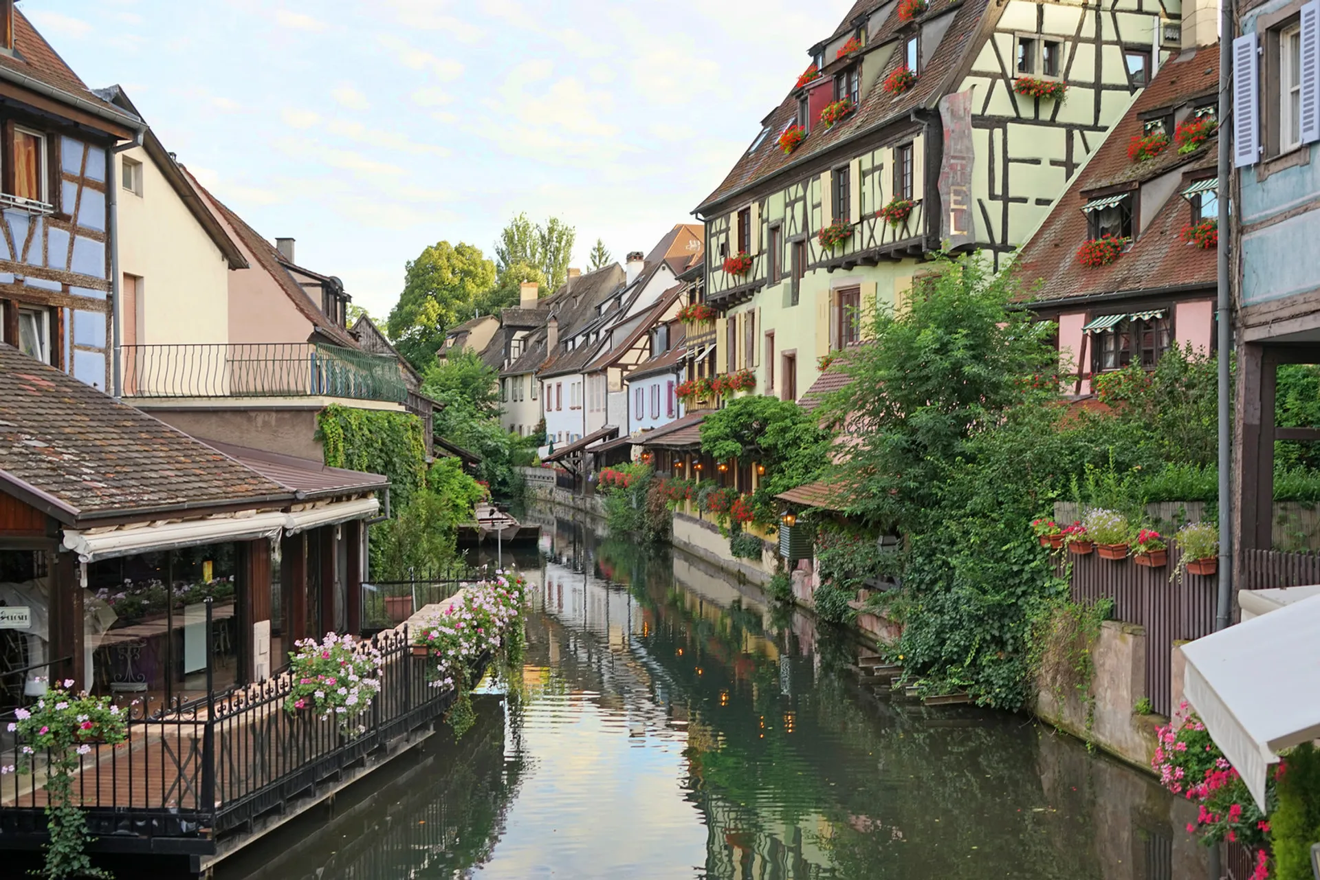 The image shows a picturesque canal scene, likely from a European town given the architectural