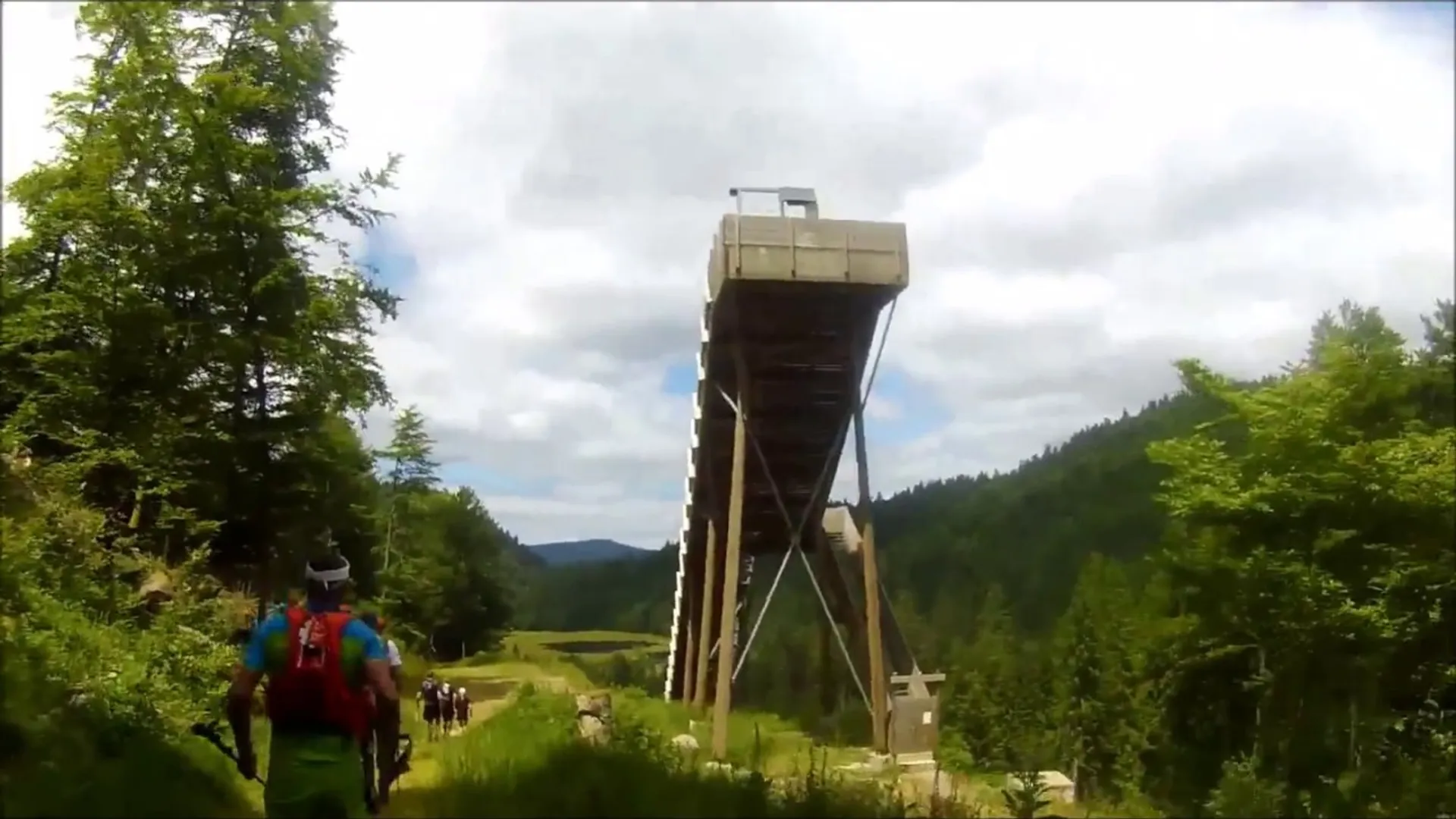 The image shows a group of hikers walking along a path leading towards a tall