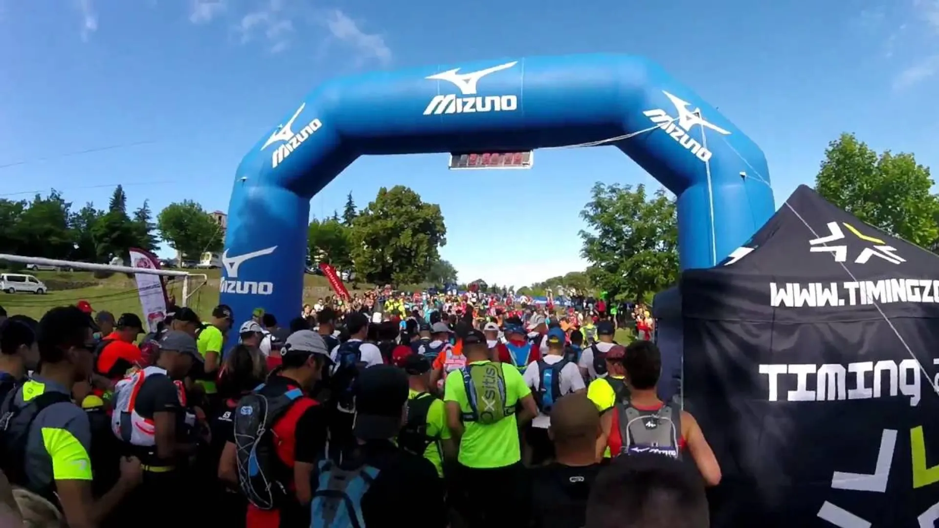 The image shows a crowd of participants at a running event, possibly a marathon or