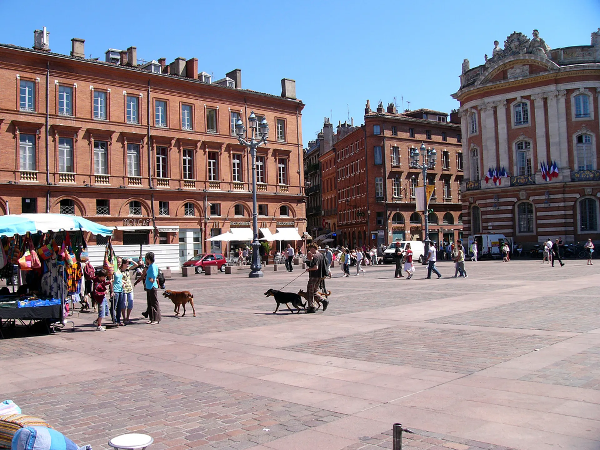 In the image, you see a spacious city square with people walking around and ming