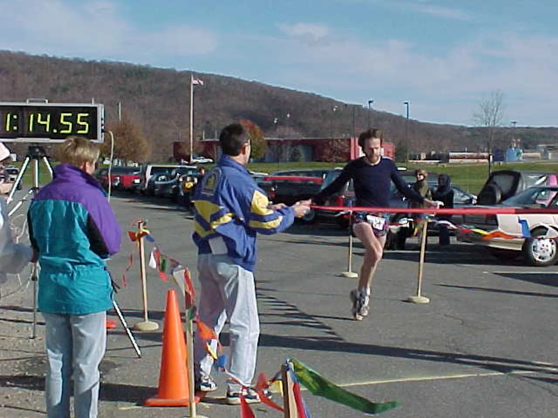 The image shows an outdoor scene where a runner is just about to cross the finish