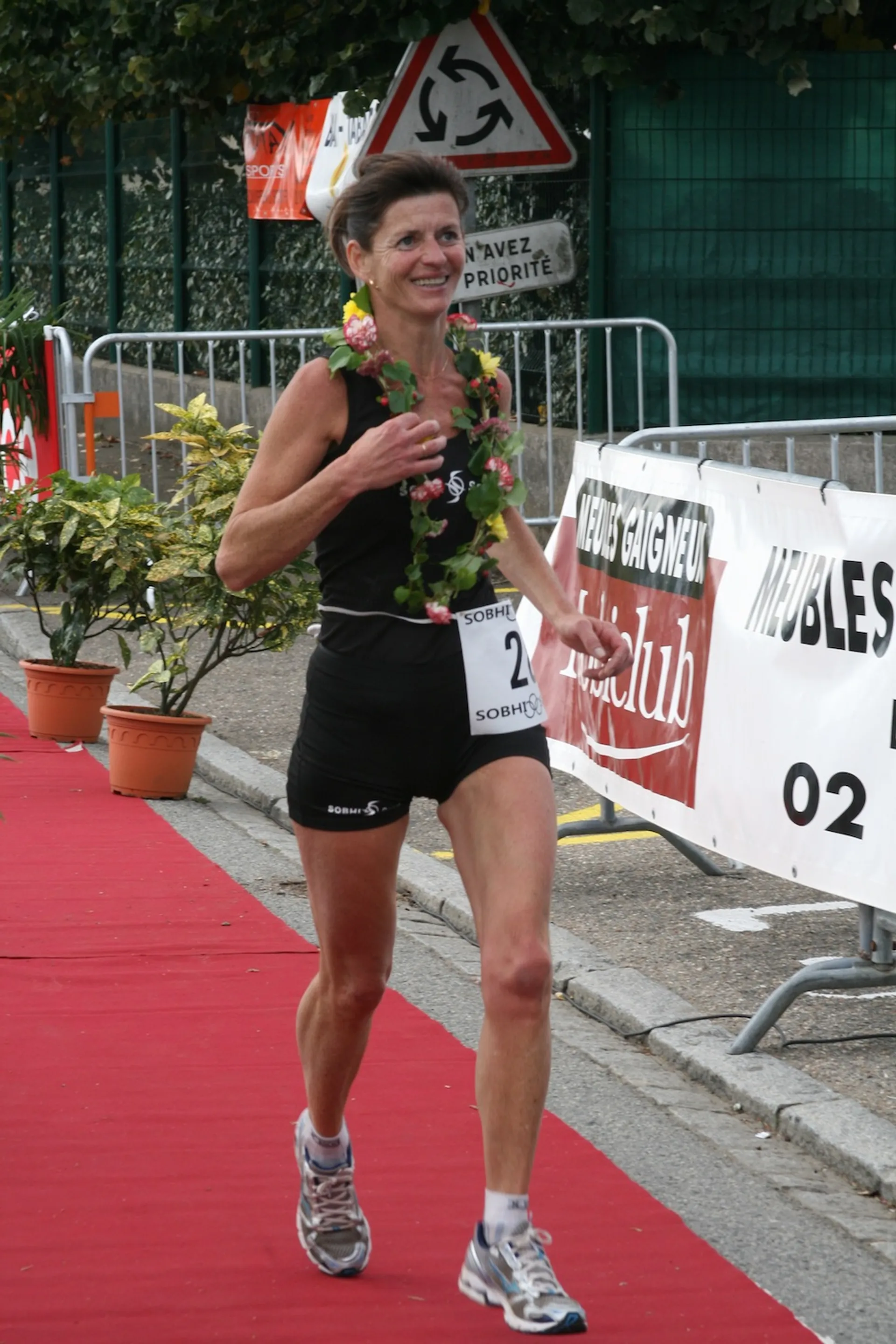 This image shows a female athlete finishing a race. She appears to be a runner