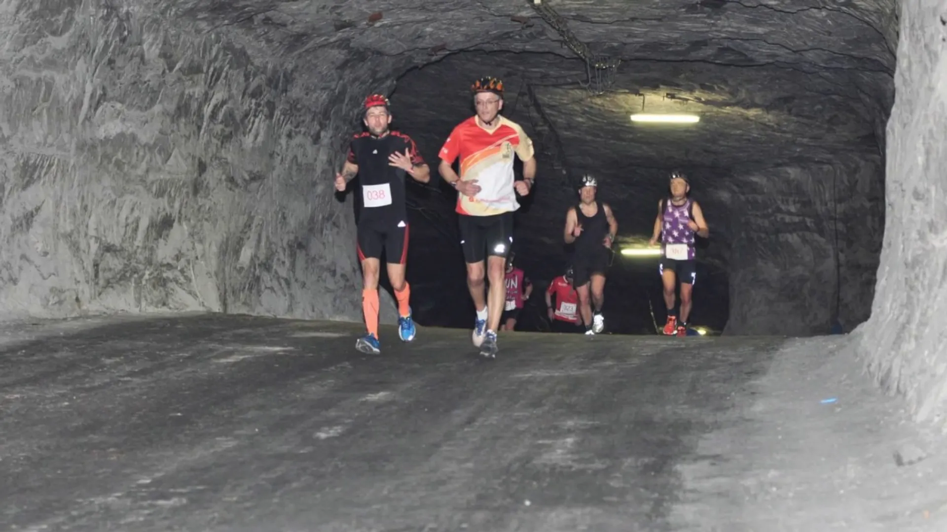 The image shows a group of runners inside what appears to be a tunnel or an