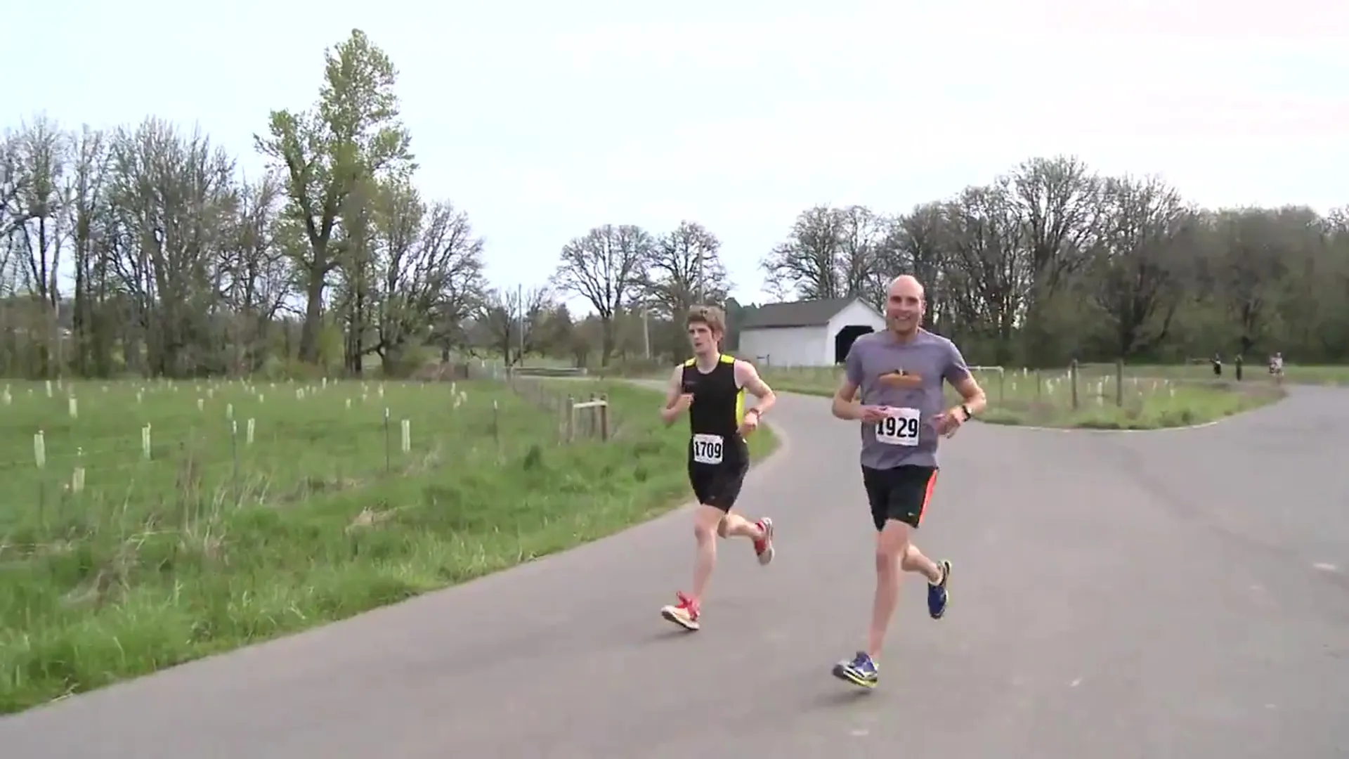 The image shows two individuals participating in a running event or race. They are dressed