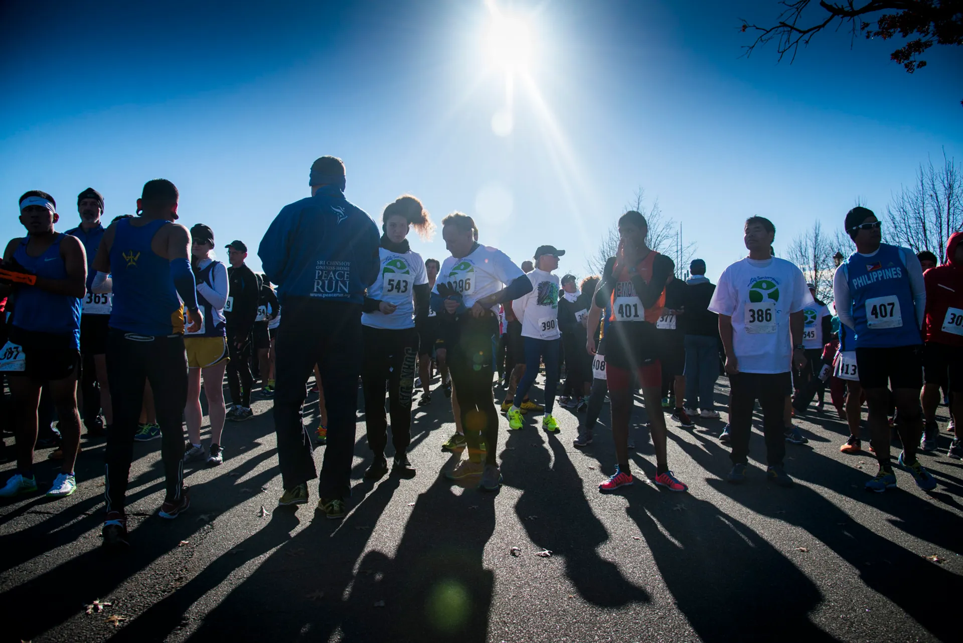 The image shows a group of people gathered outdoors, likely at a running event or