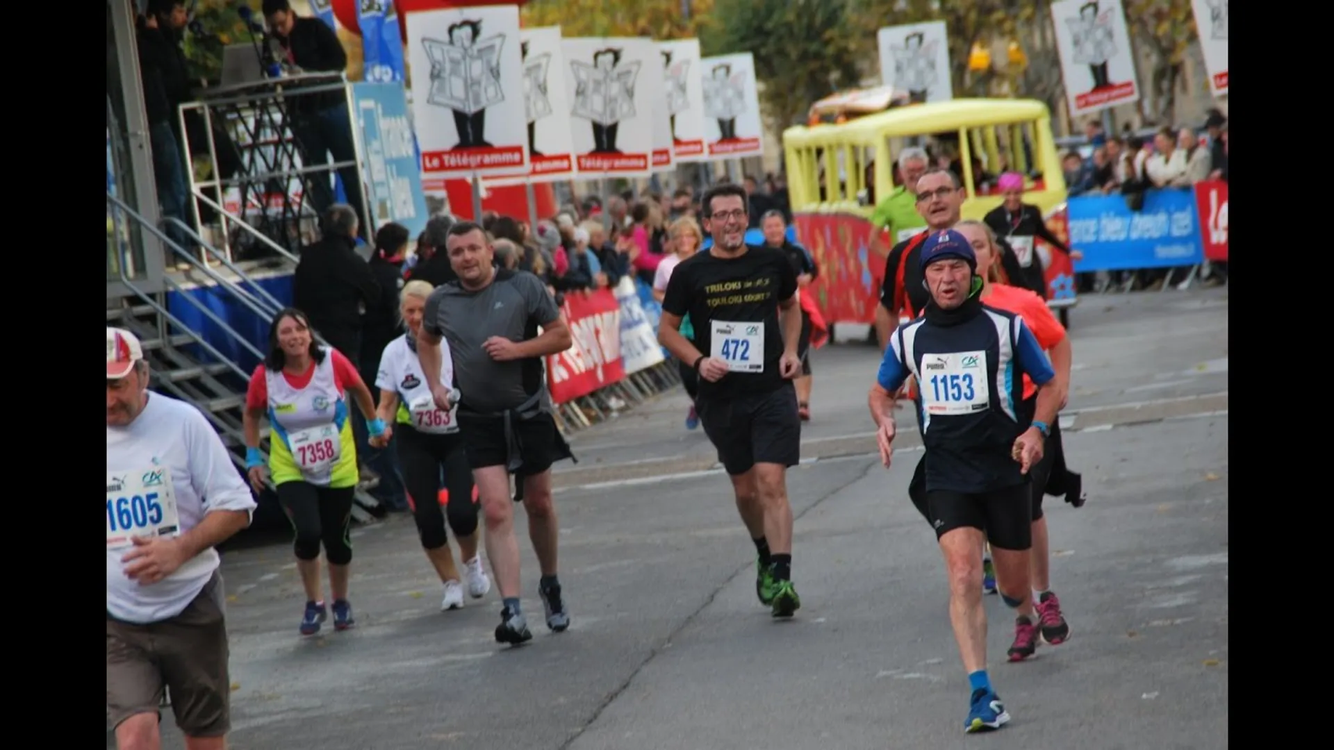 The image shows a group of people participating in a running event. The runners are