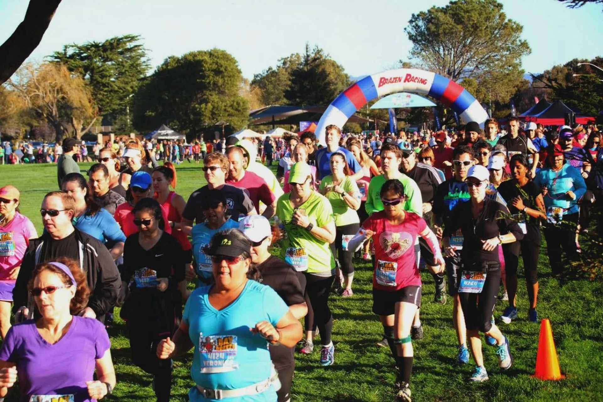 The image depicts a group of people participating in a running event. They are passing