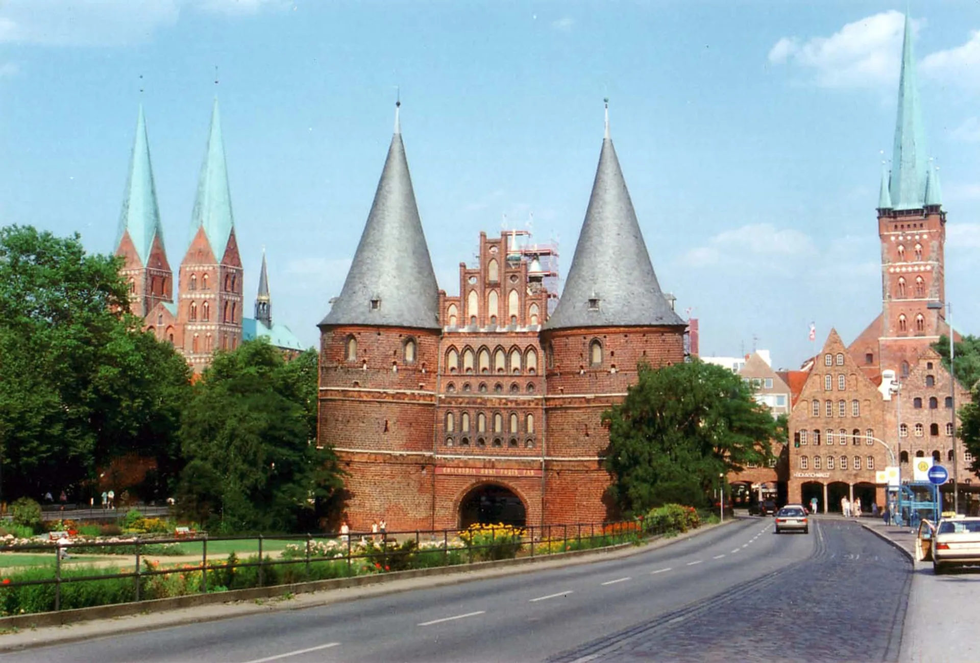This image shows a historic brick gothic city gate, flanked by two round