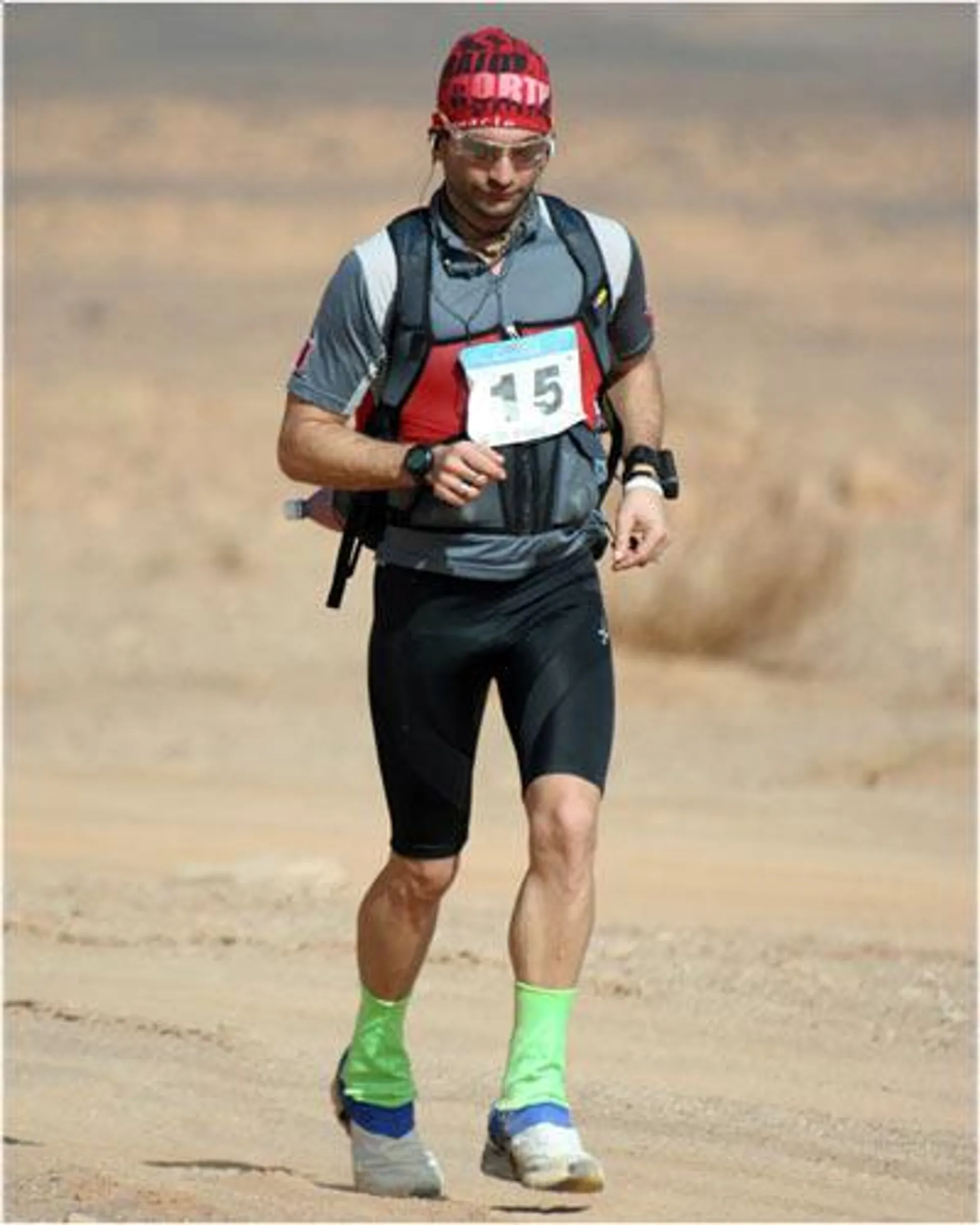 The image shows a male runner participating in a long-distance or endurance event, likely