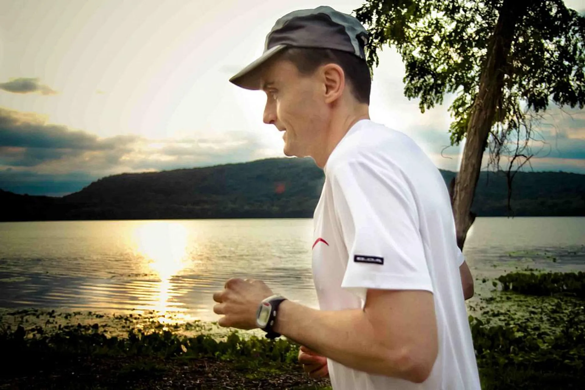 The image shows a person jogging. The person is wearing a cap, a white