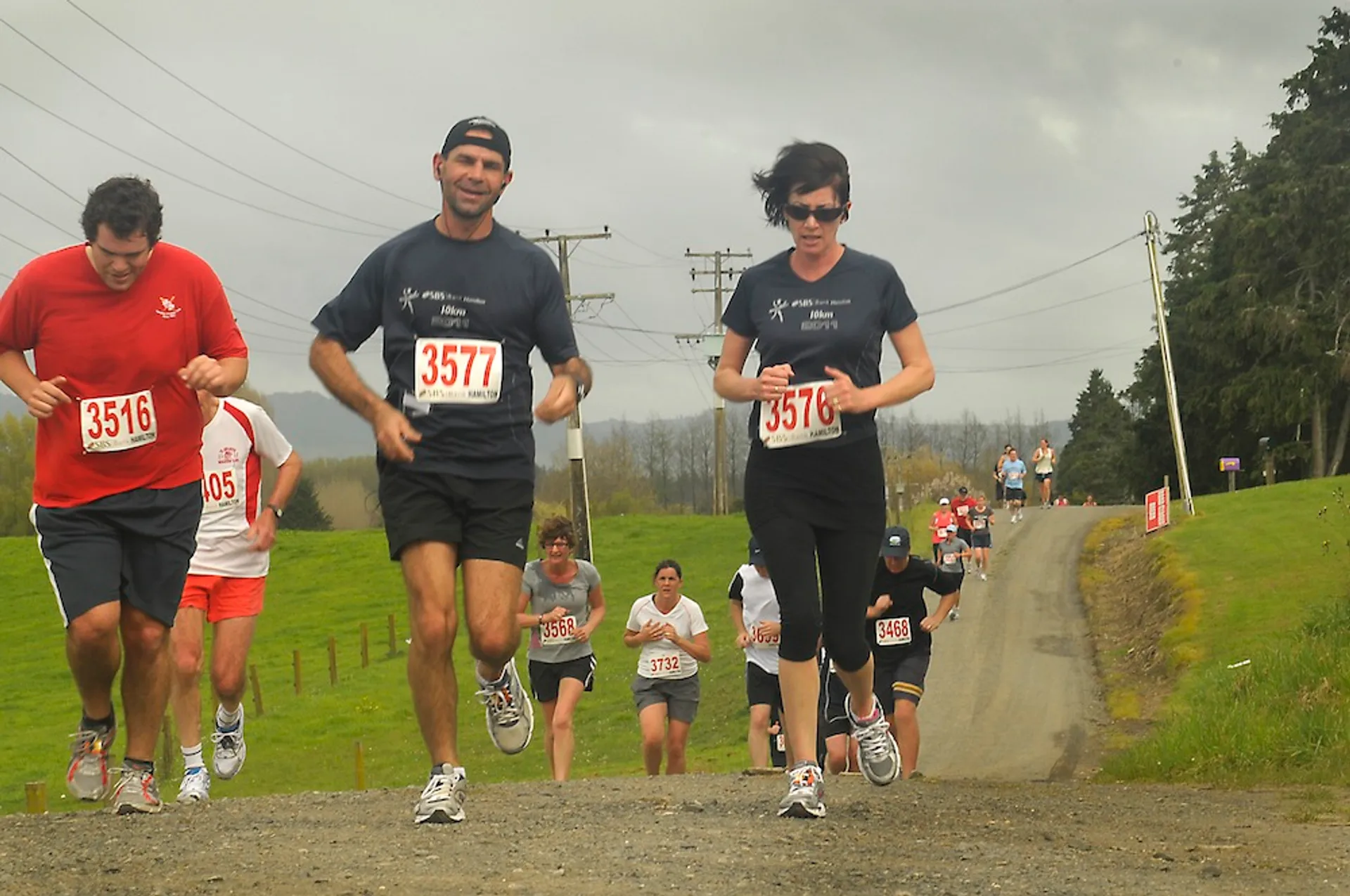 The image shows a group of people participating in a running event or race. They