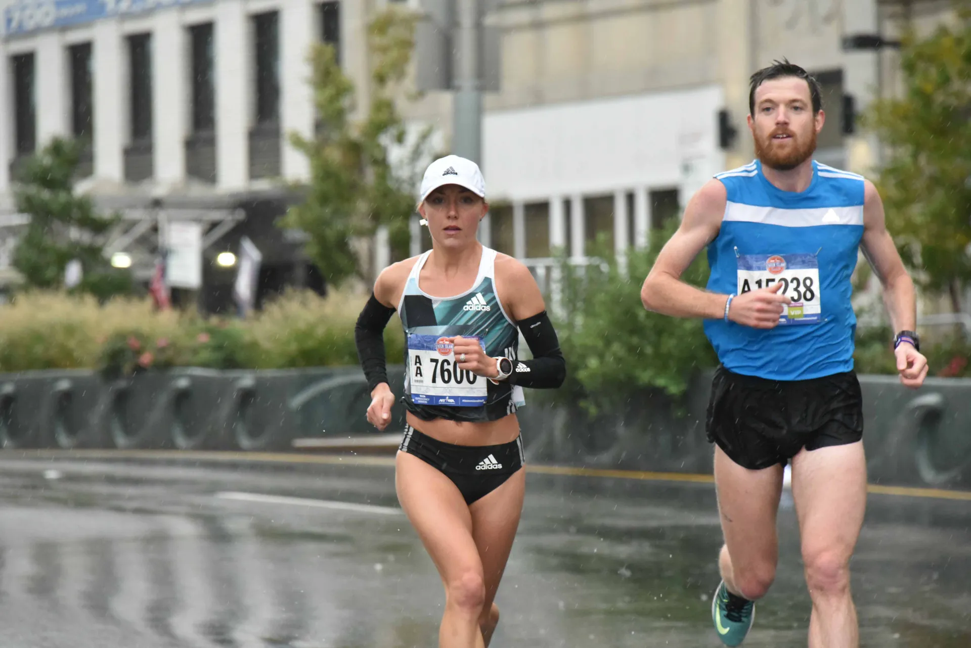 The image shows two runners, a woman and a man, participating in a road