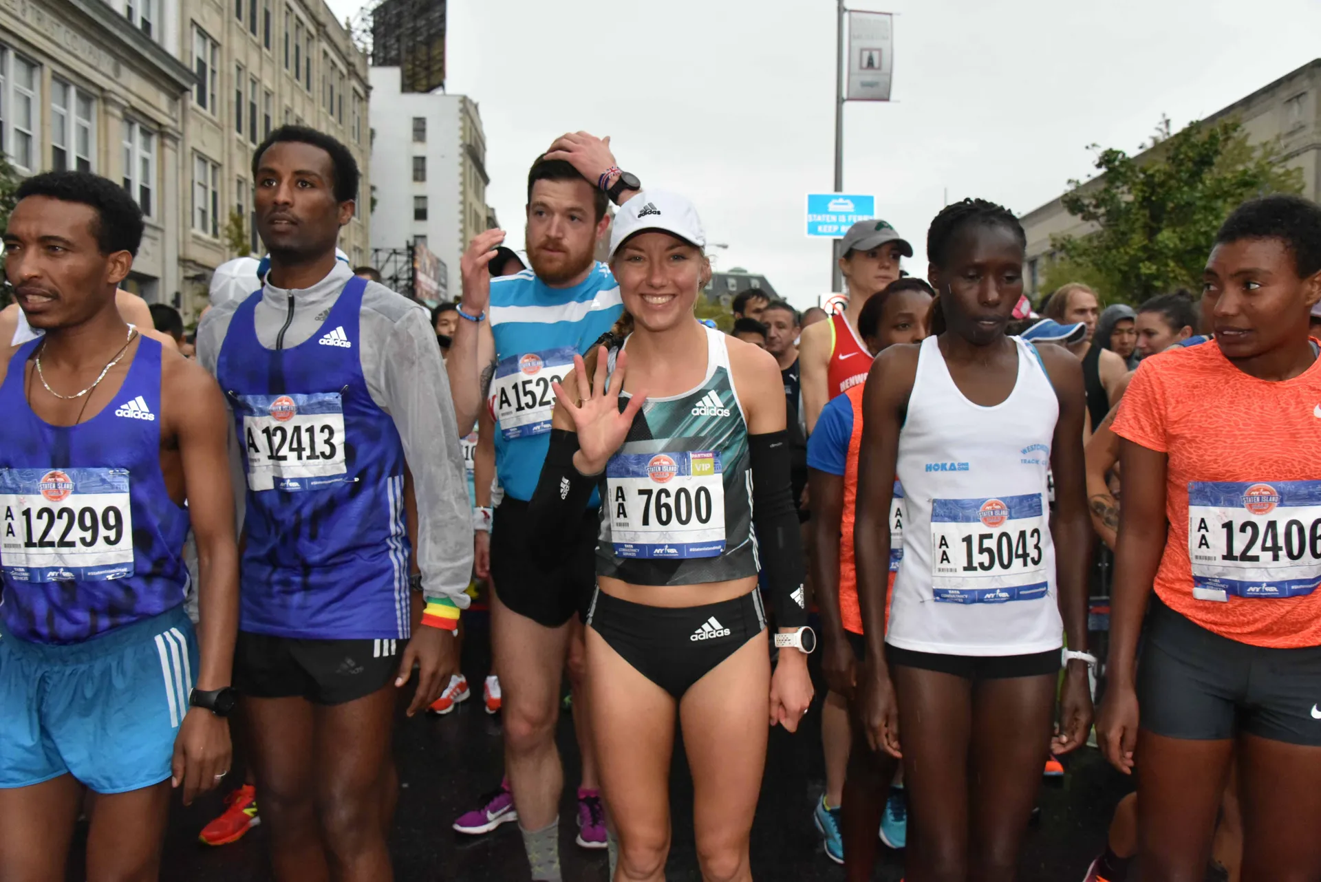 The image shows a group of people at a running event, likely a marathon or