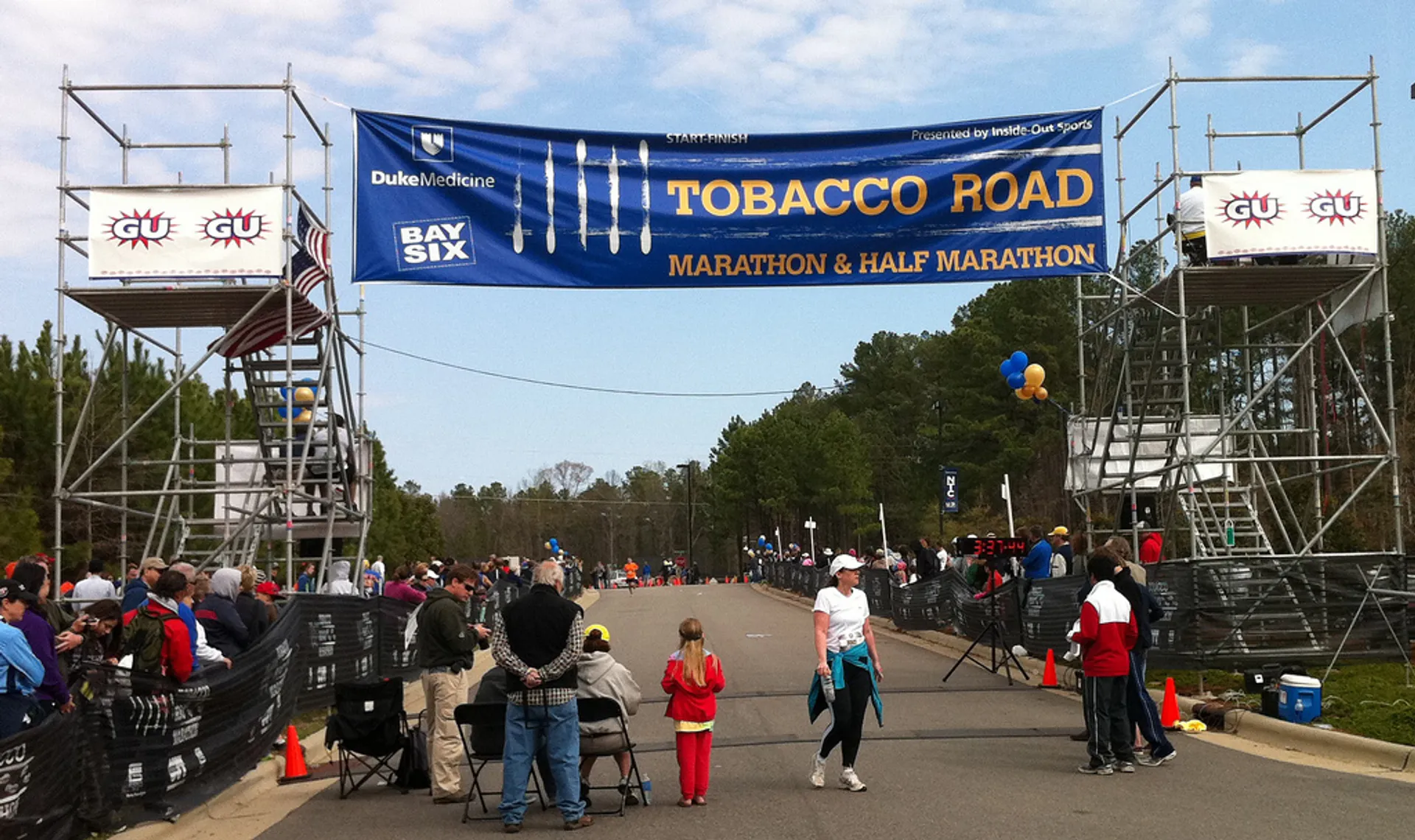 The image shows a road race event, specifically the Tobacco Road Marathon and Half Marathon