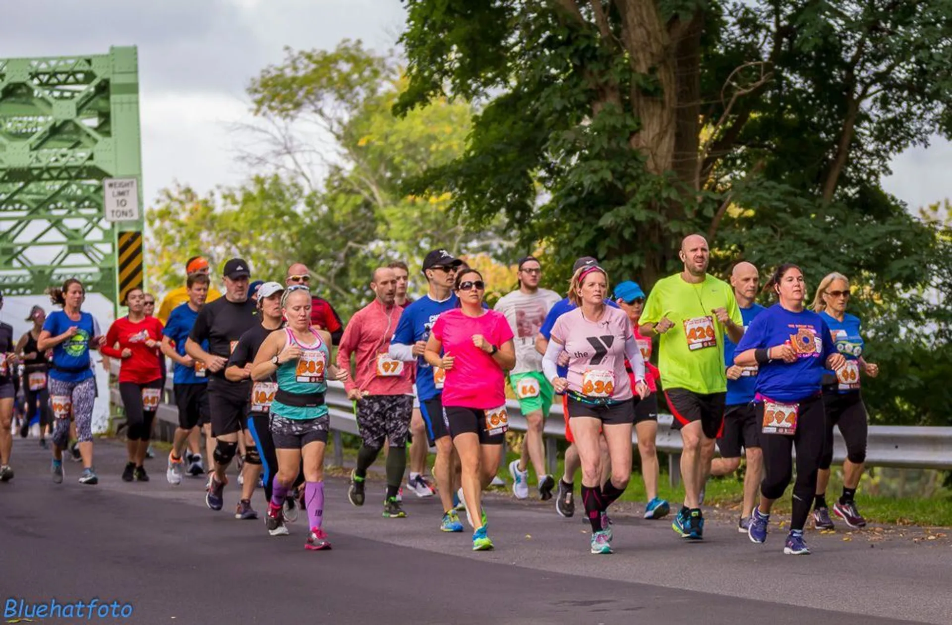The image shows a group of people participating in a running event. They are on