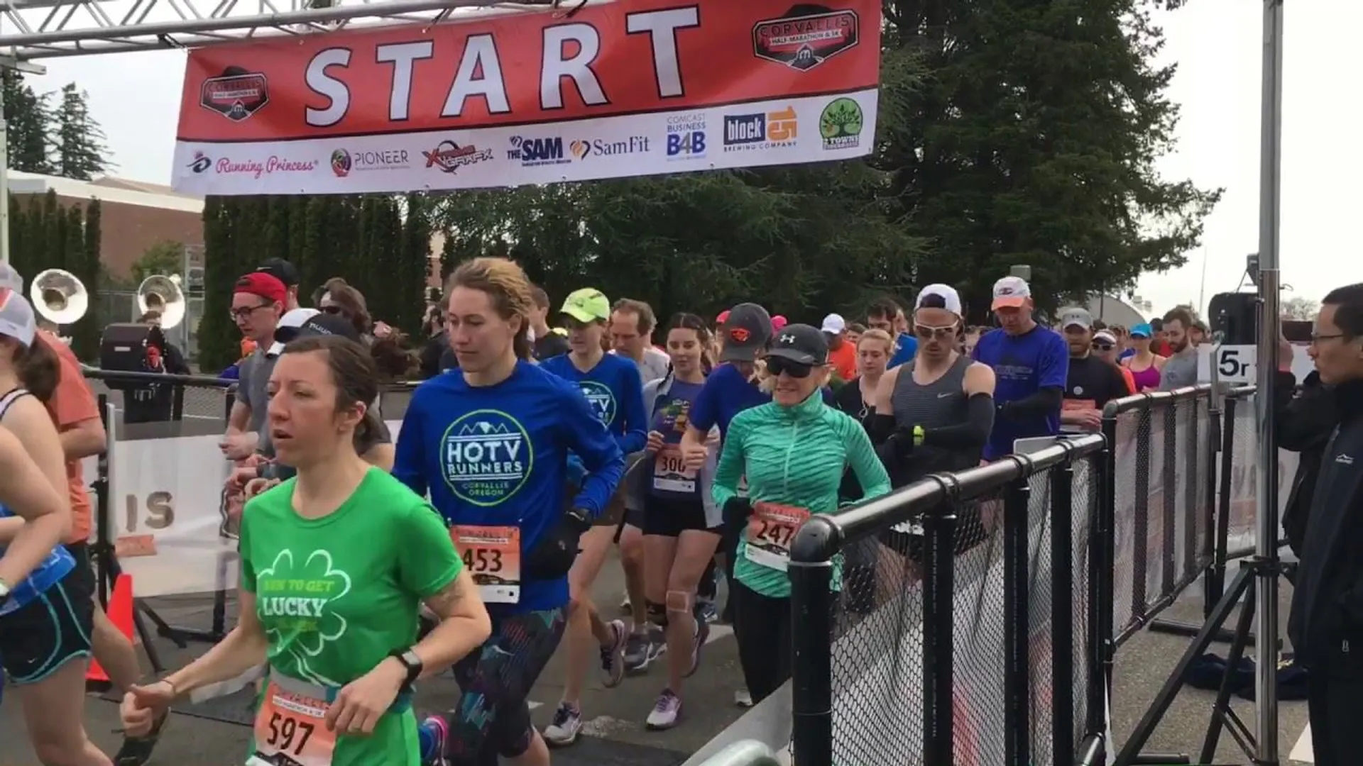 The image shows a group of people participating in a running event. They are crossing