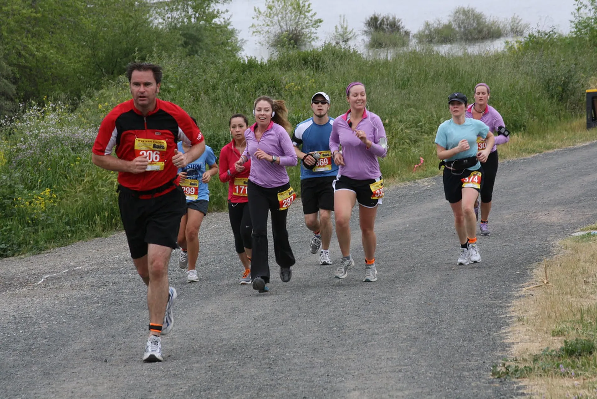 The image depicts a group of people engaged in a running event. There is a