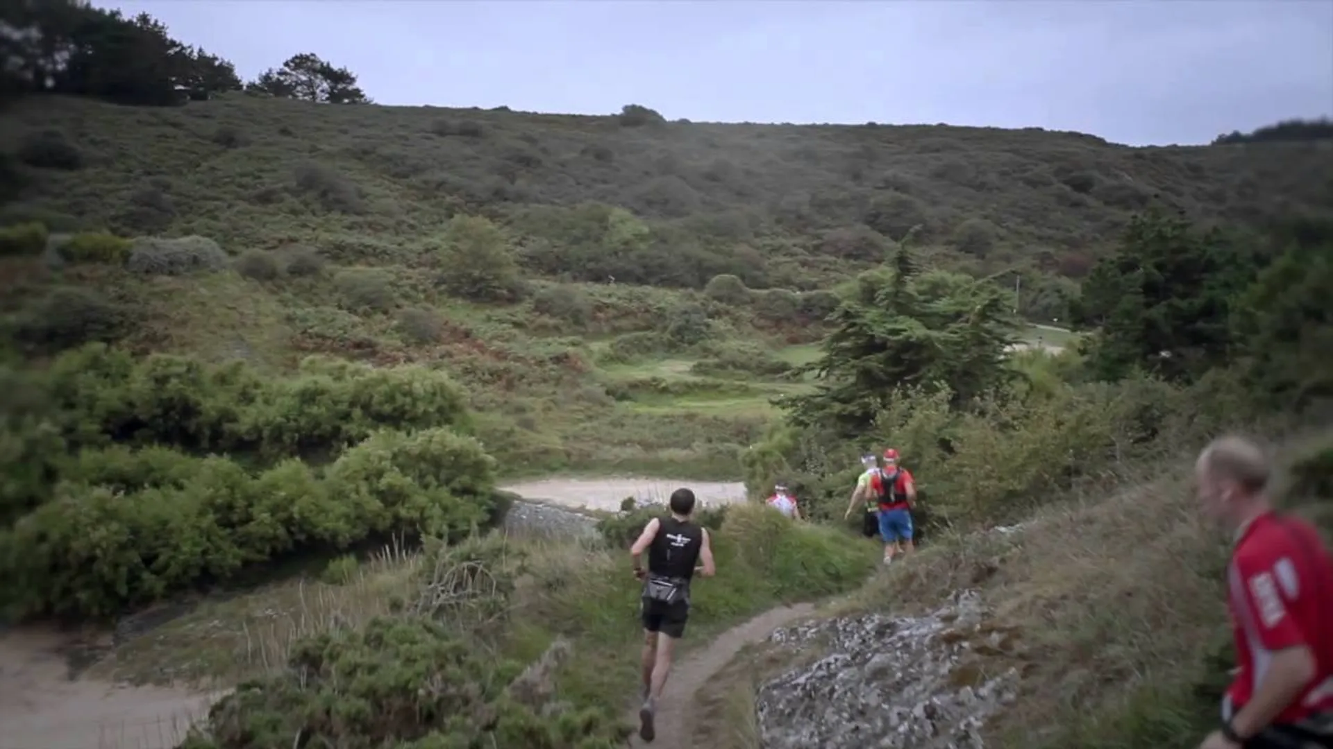 The image shows a group of people participating in what appears to be a trail running
