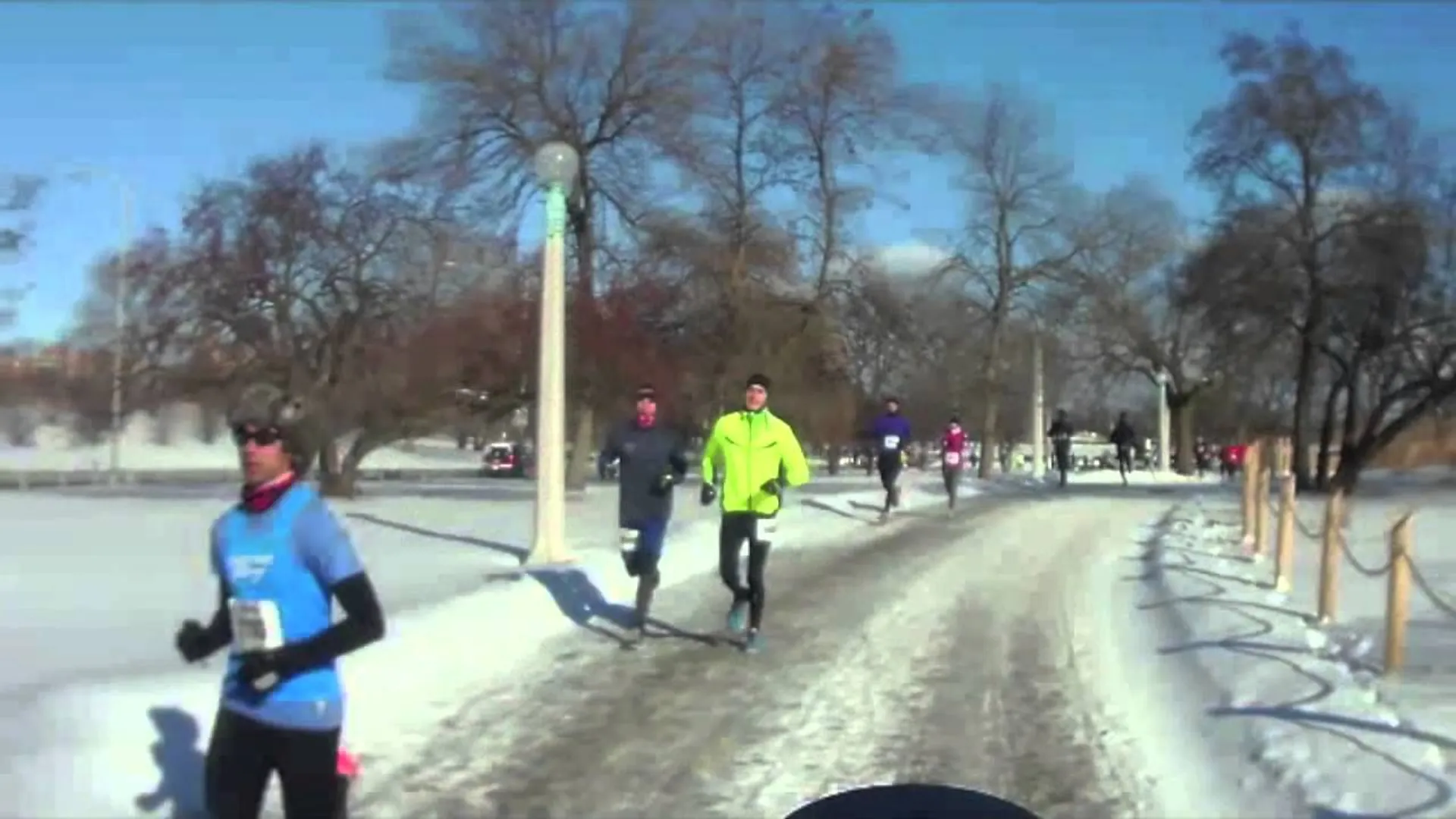 The image displays a snowy outdoor scene where a group of people are engaged in running