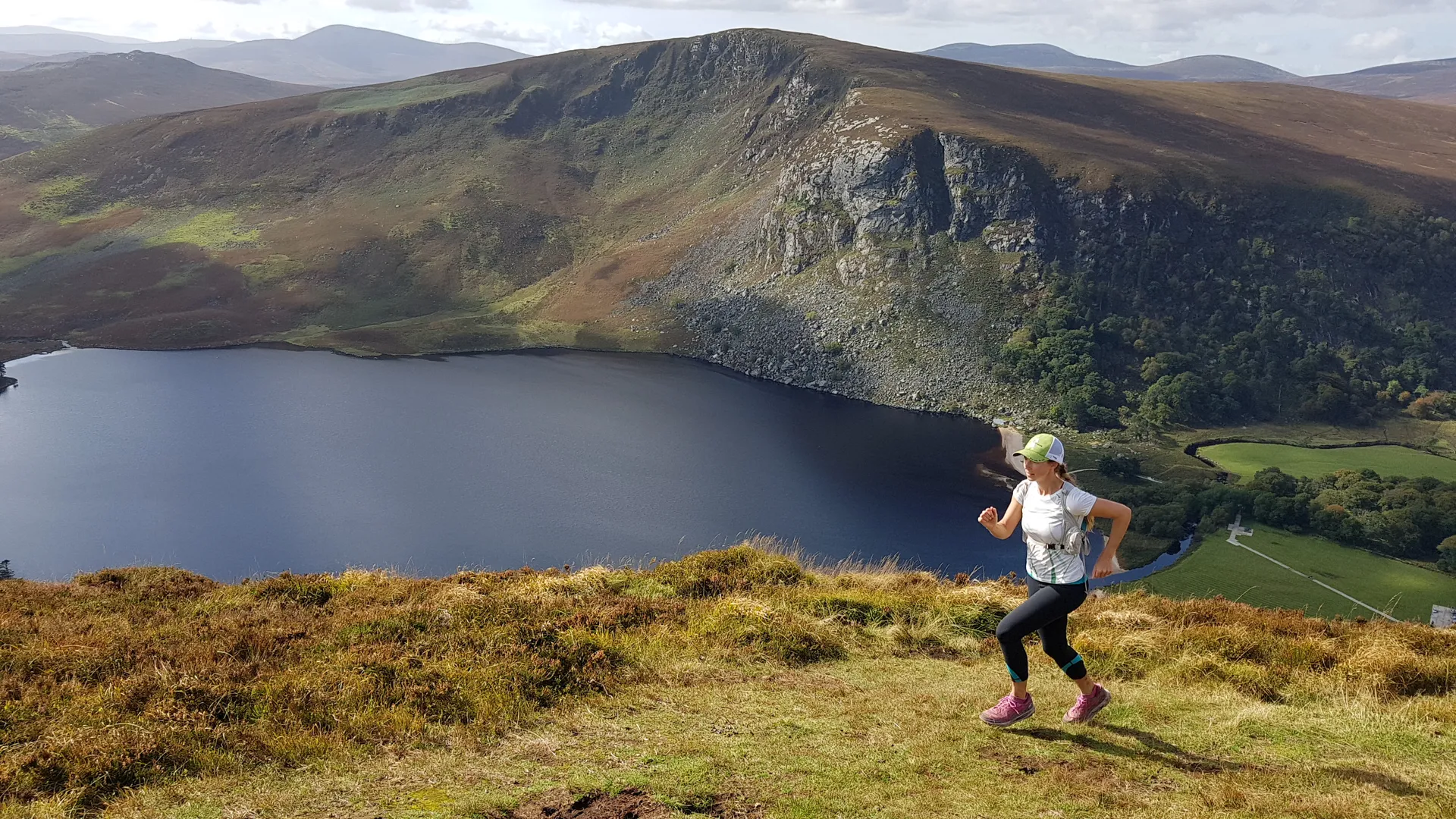 The image features a person running through a scenic landscape. They are on a grass