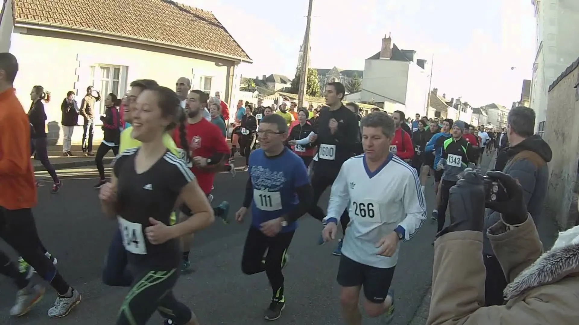 The image shows a group of people running in what appears to be a road race