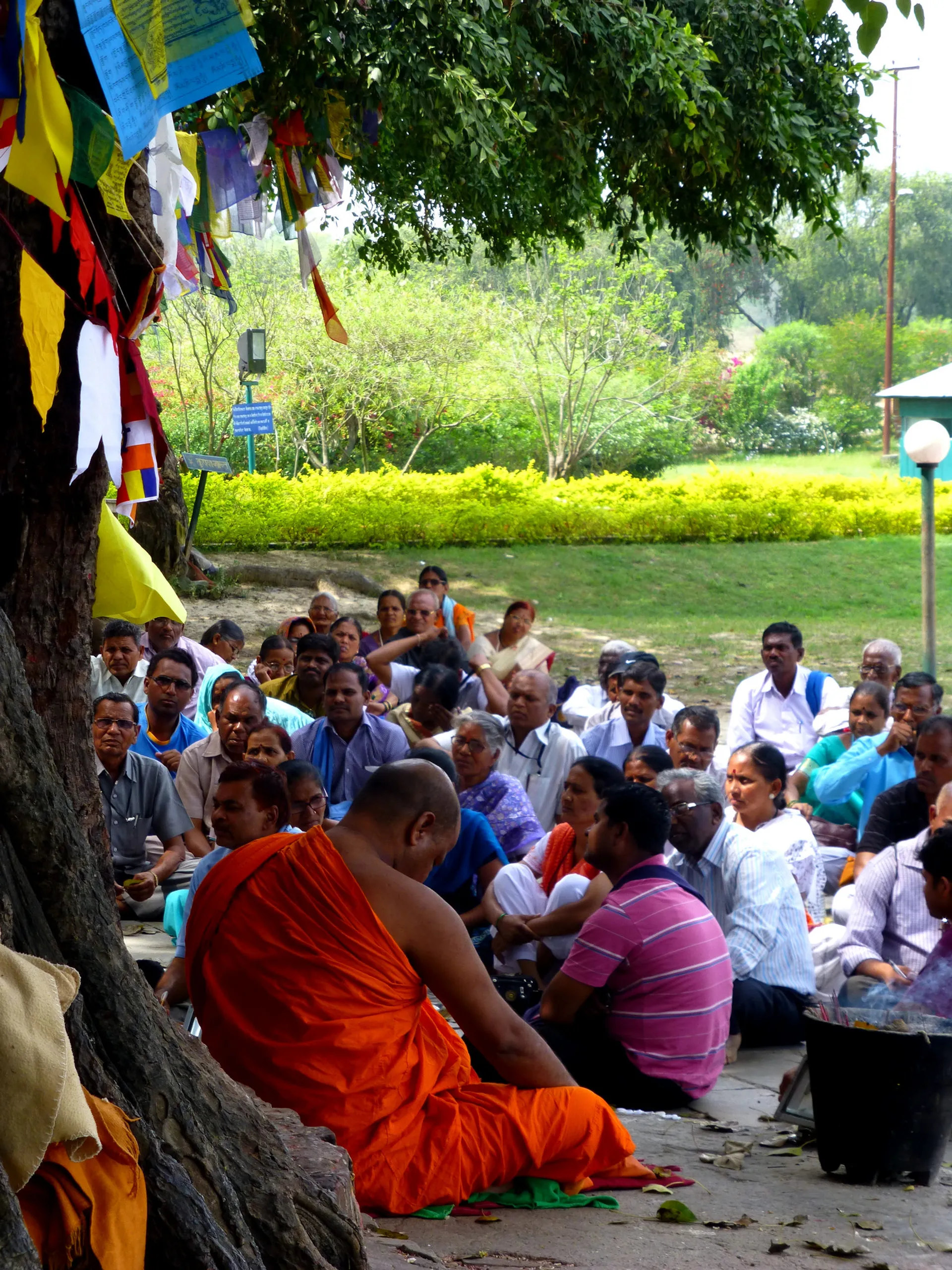 The image shows a group of people sitting outdoors in what appears to be a peaceful