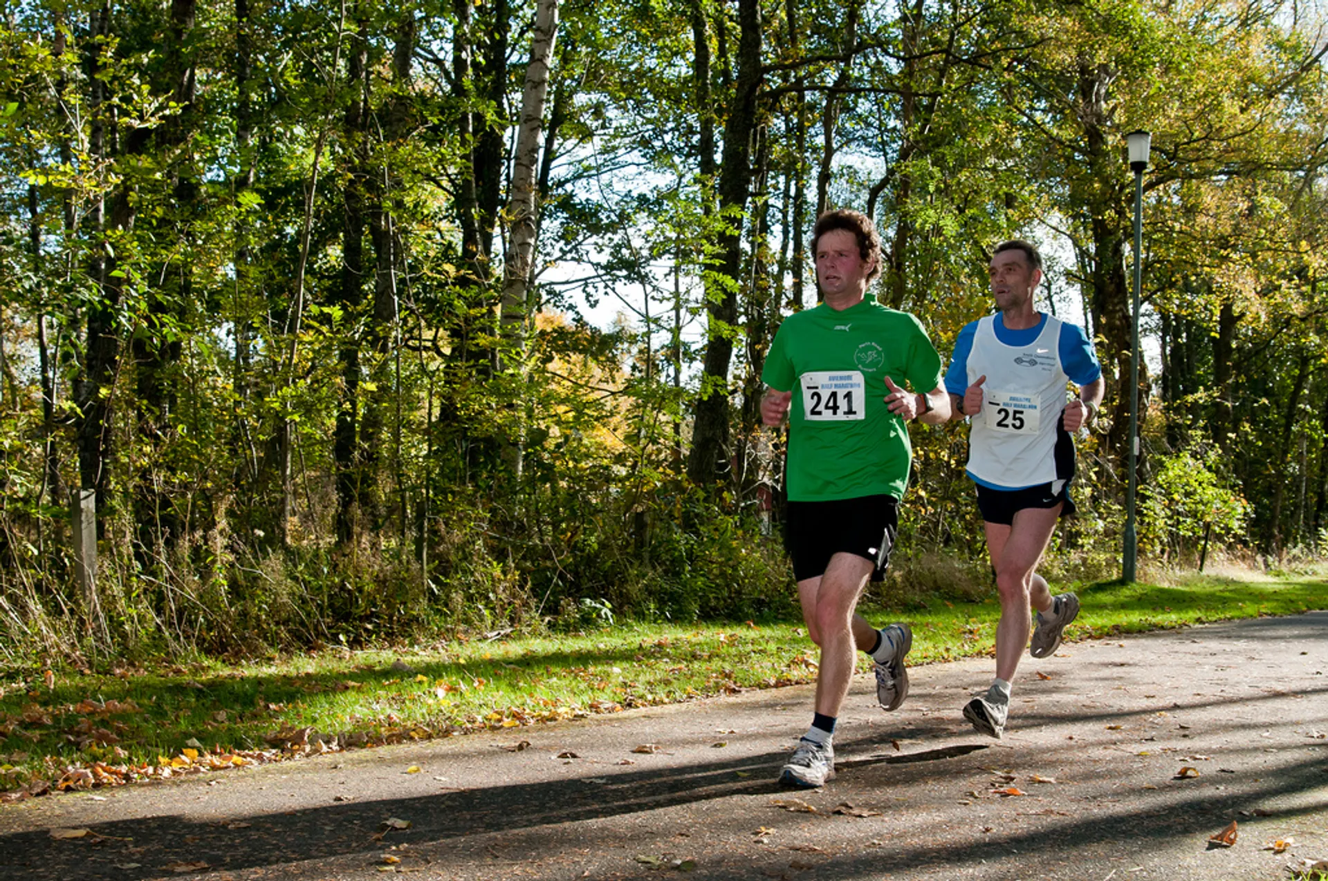 The image shows two individuals participating in a running event, likely a race or marathon