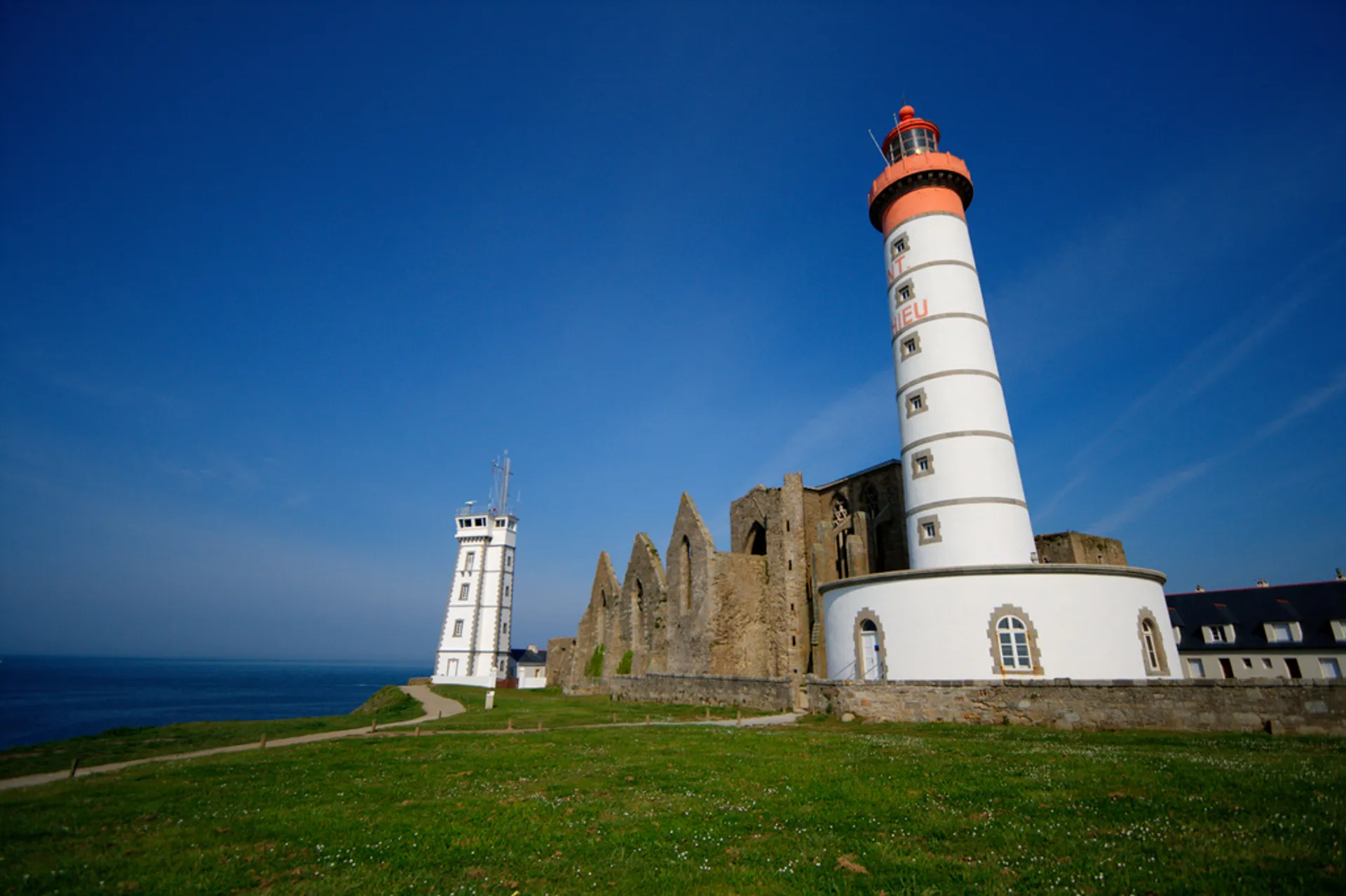 The image features a coastal scene with a prominent lighthouse and a smaller white building