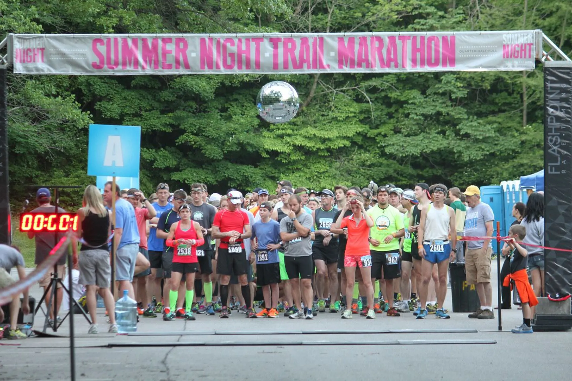 The image shows a group of runners at the start line of the "Summer Night