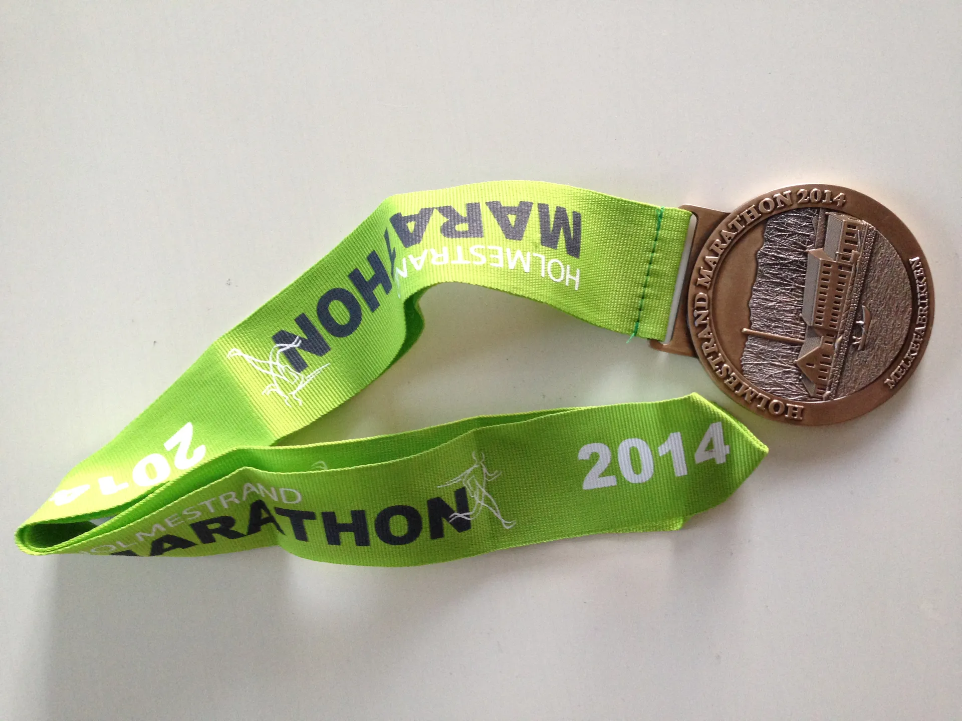 The image shows a finisher medal from a marathon event. The medal is attached