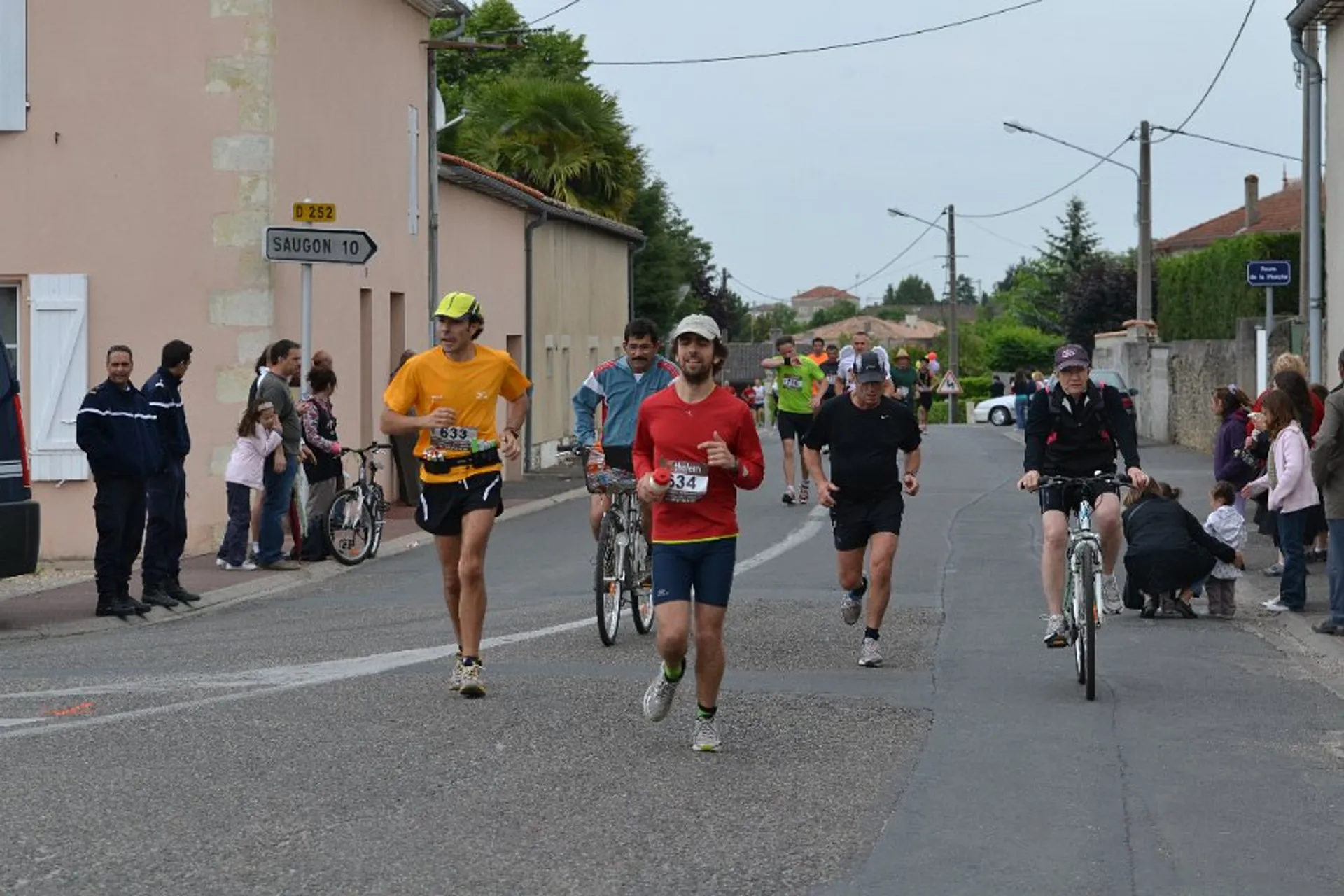 The image shows a group of people engaged in a running event on a road.