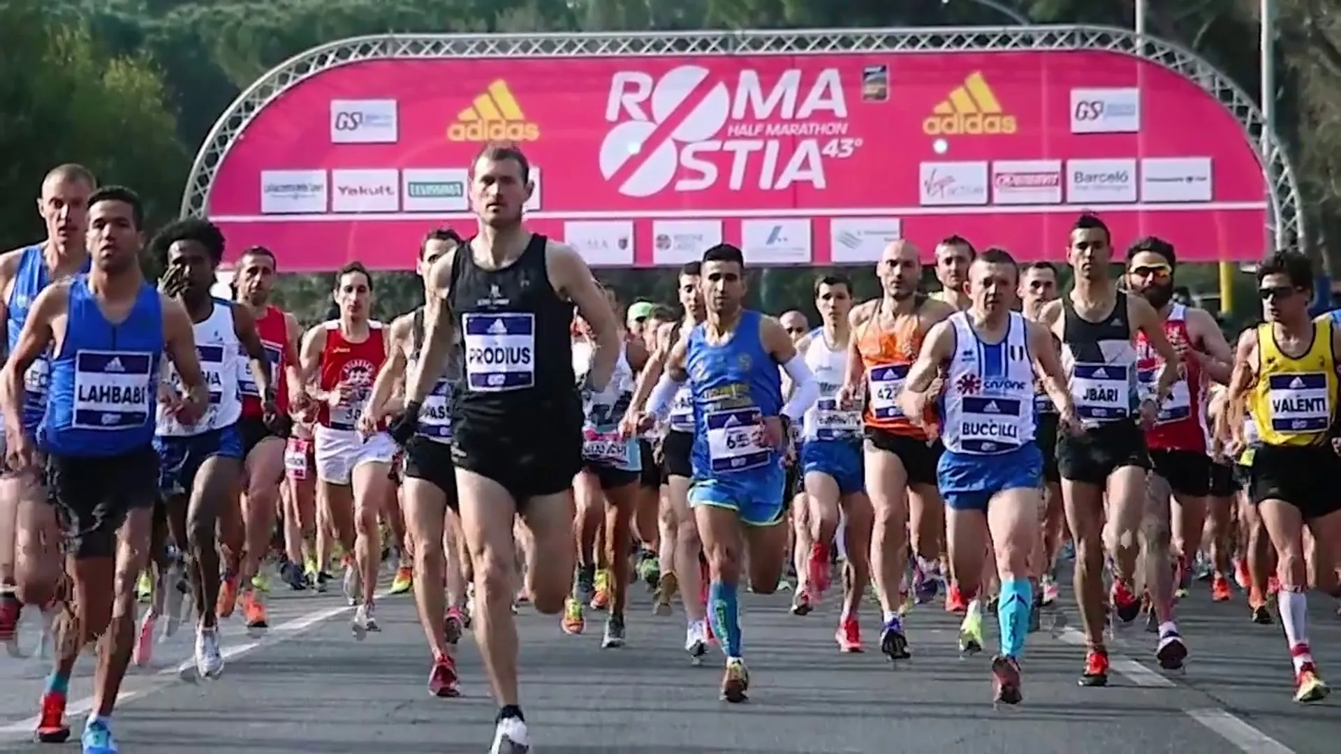 The image shows a group of runners participating in a road race, likely a marathon