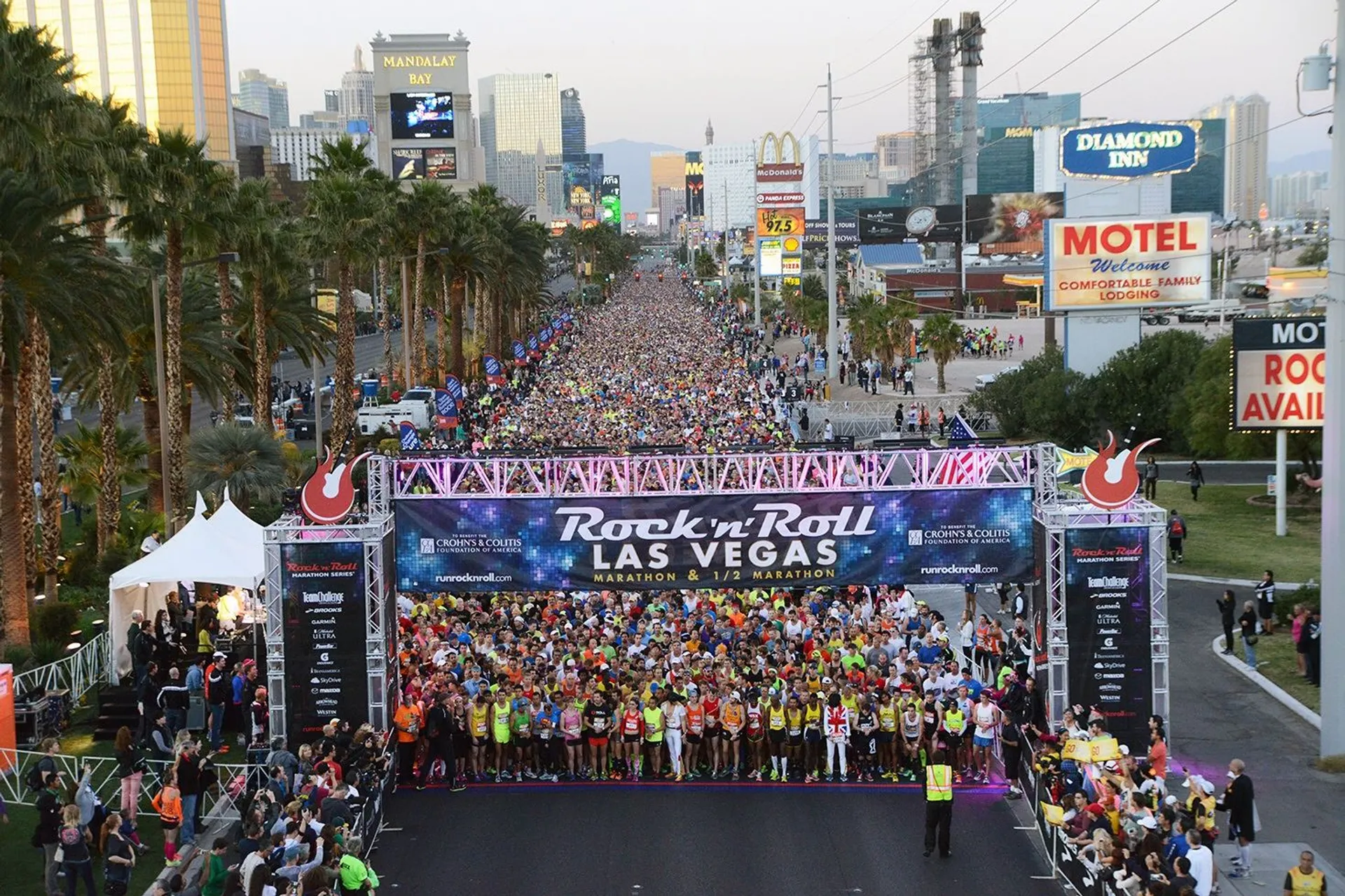 The image shows a large crowd of participants at the starting line of the Rock '
