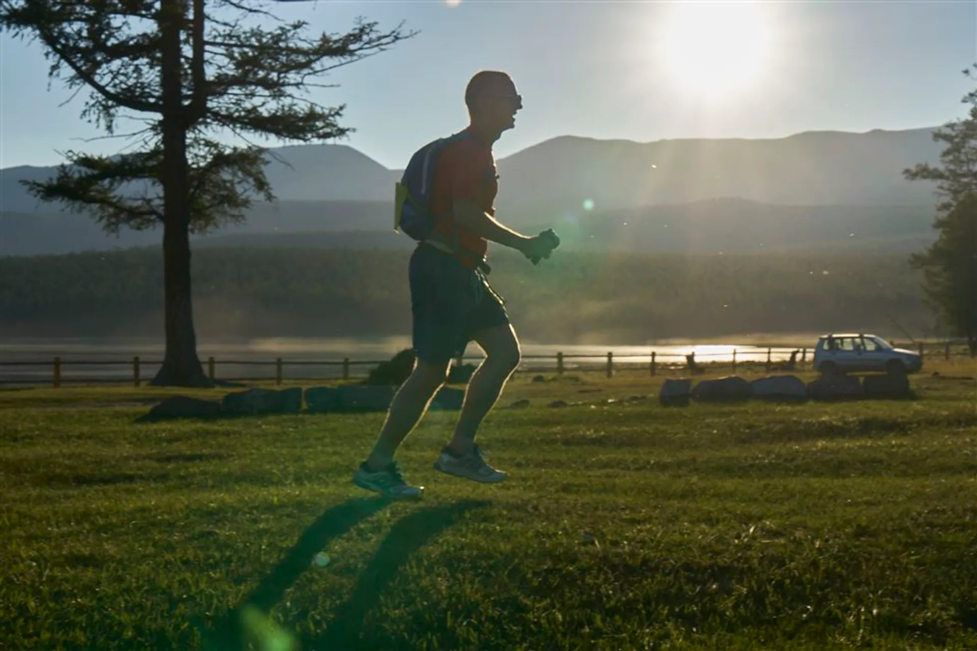 The image shows a person jogging in a scenic outdoor setting during what appears to be