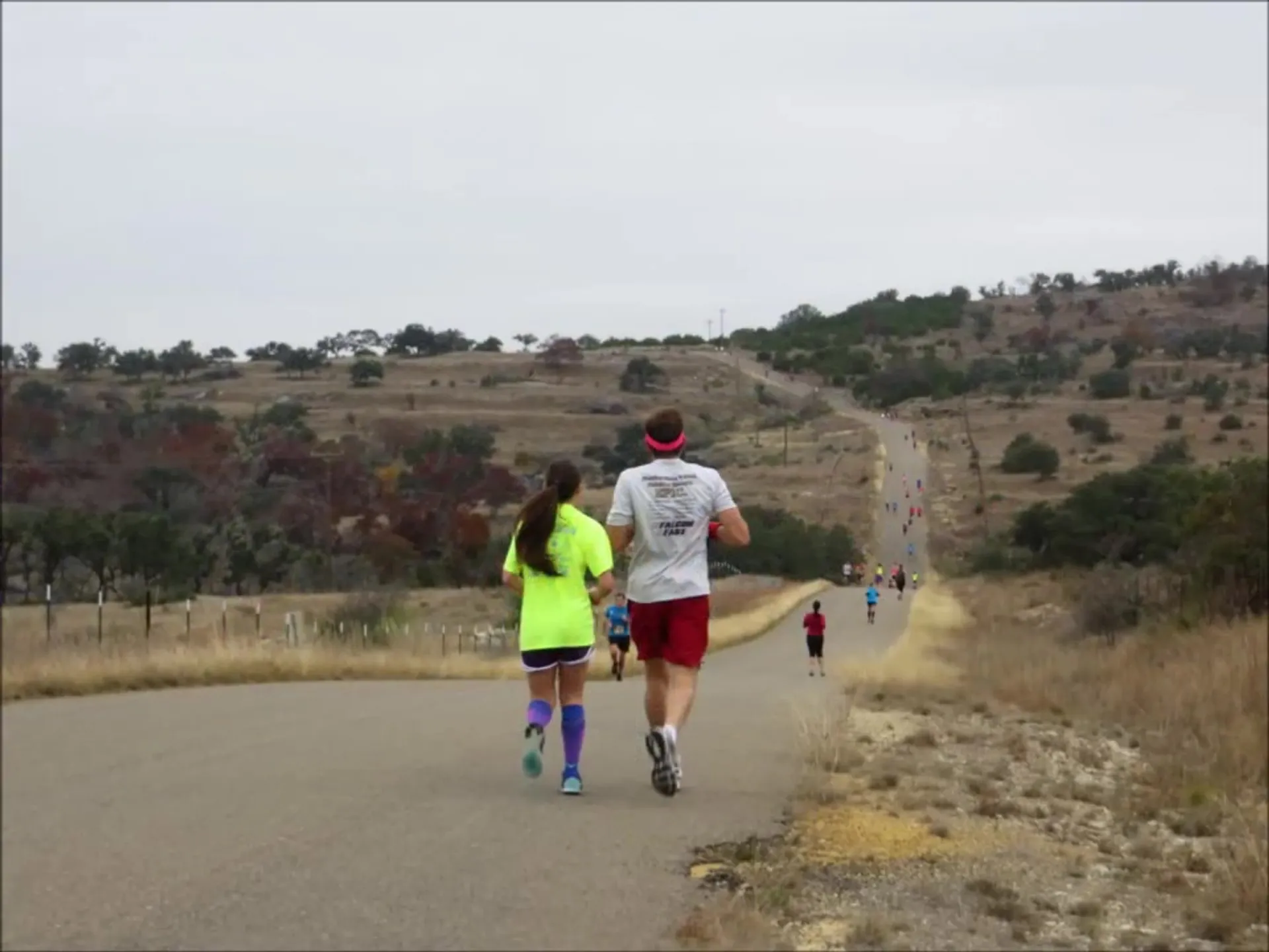 The image shows a group of people engaged in a running event or race. Two