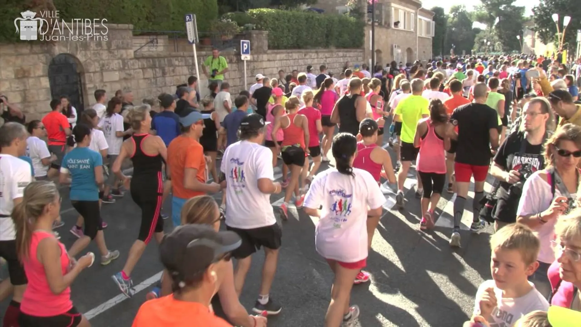 The image depicts a large group of people participating in a running event. It appears