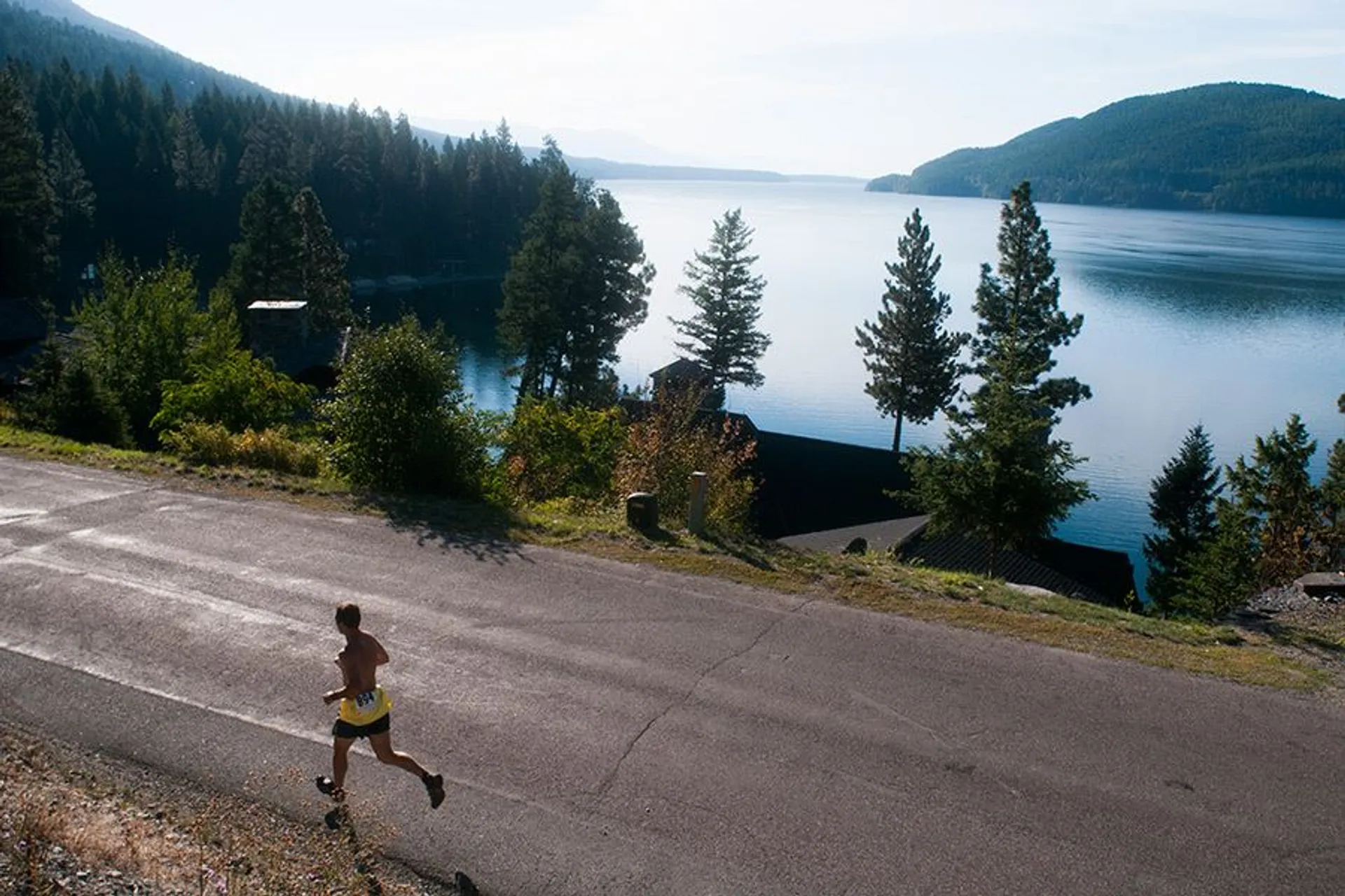 The image shows a scenic view of a runner jogging along a road next to a