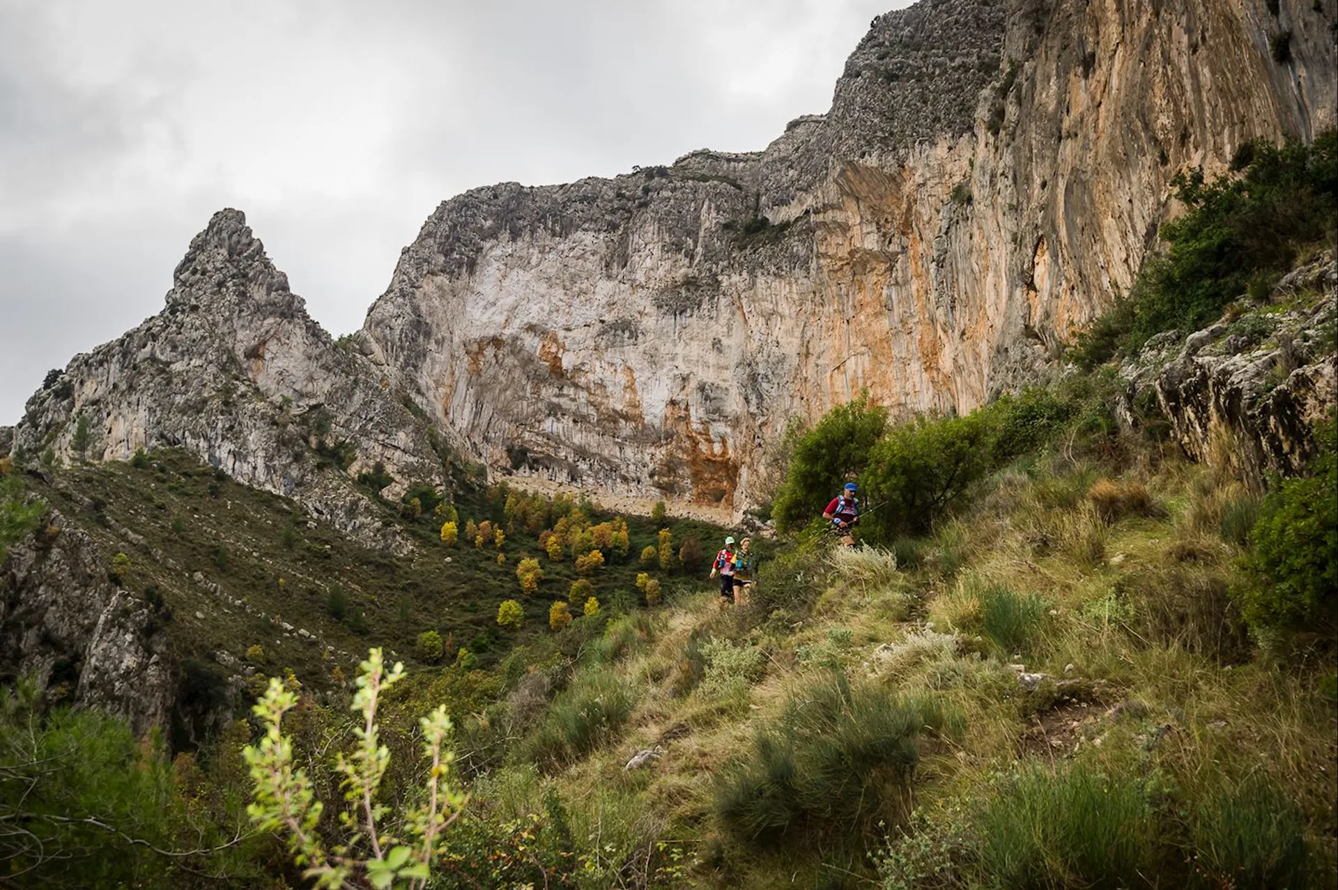 The image shows a scenic mountainous landscape with a rocky cliff face on the right