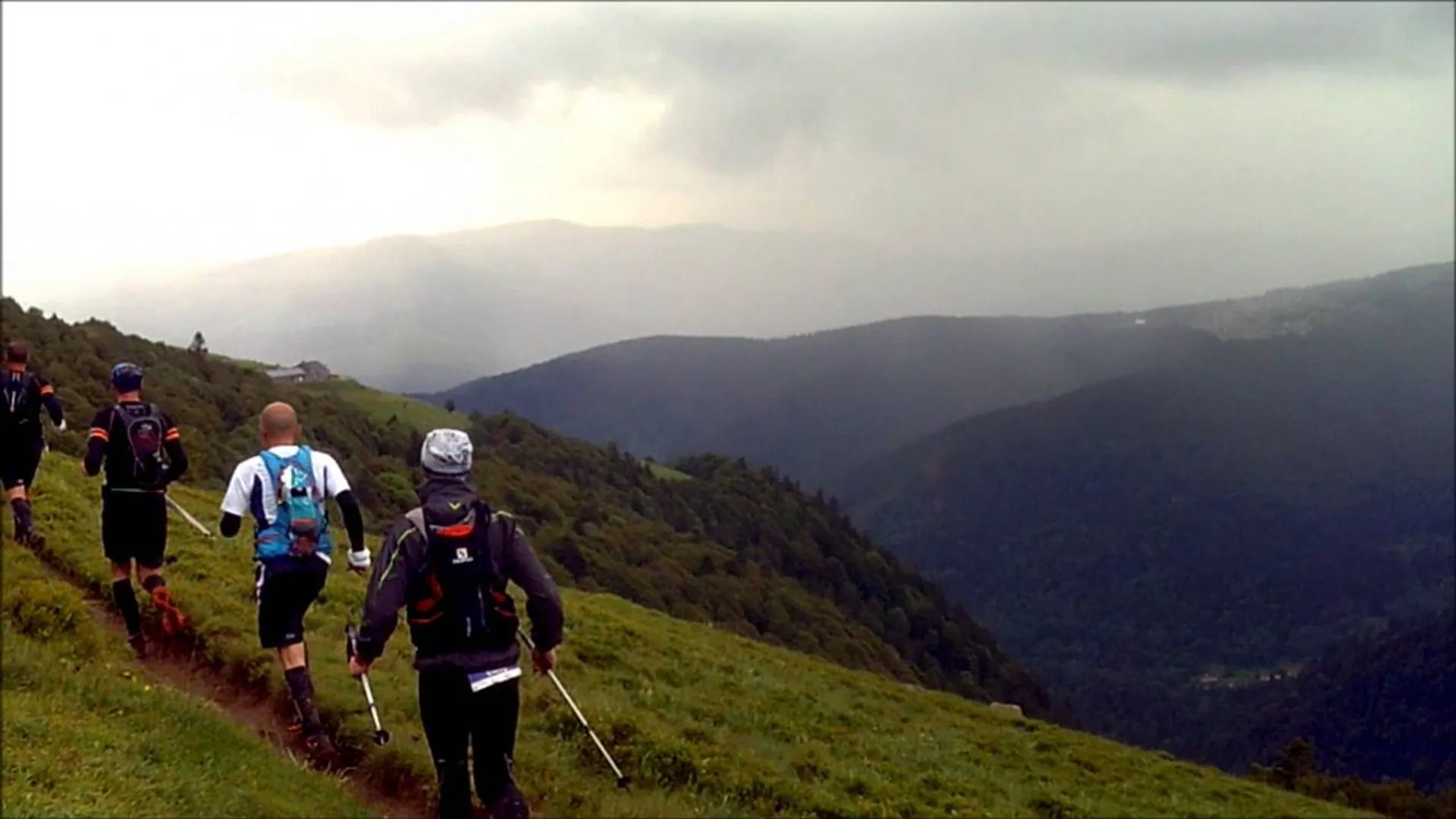 The image shows a group of hikers or trail runners equipped with backpacks and