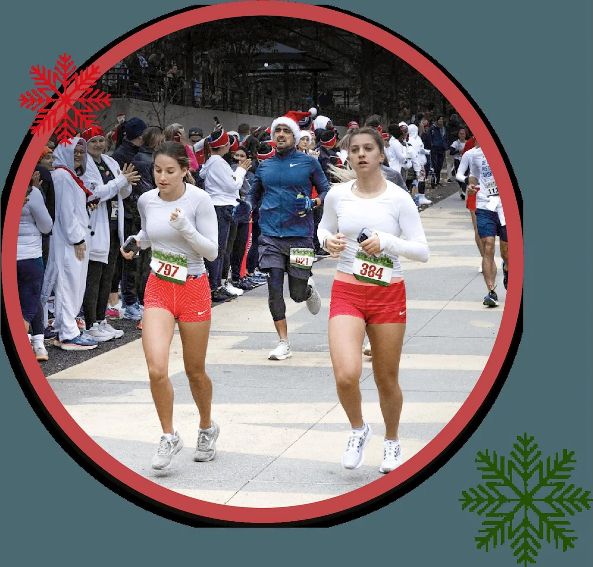 This image shows a circular frame with a red border decorated with snowflake designs, suggesting a holiday theme. Inside the frame, two individuals appear to be dressed in festive running attire that includes Santa hats, running shorts, and white shirts, indicating that they might be participating in a holiday-themed run or race. Other participants can be seen in the background, with at least one in more typical athletic gear, suggesting a mix of casual and more competitive runners in the event. The environment looks like an urban area with trees that have shed their leaves, consistent with a winter setting.